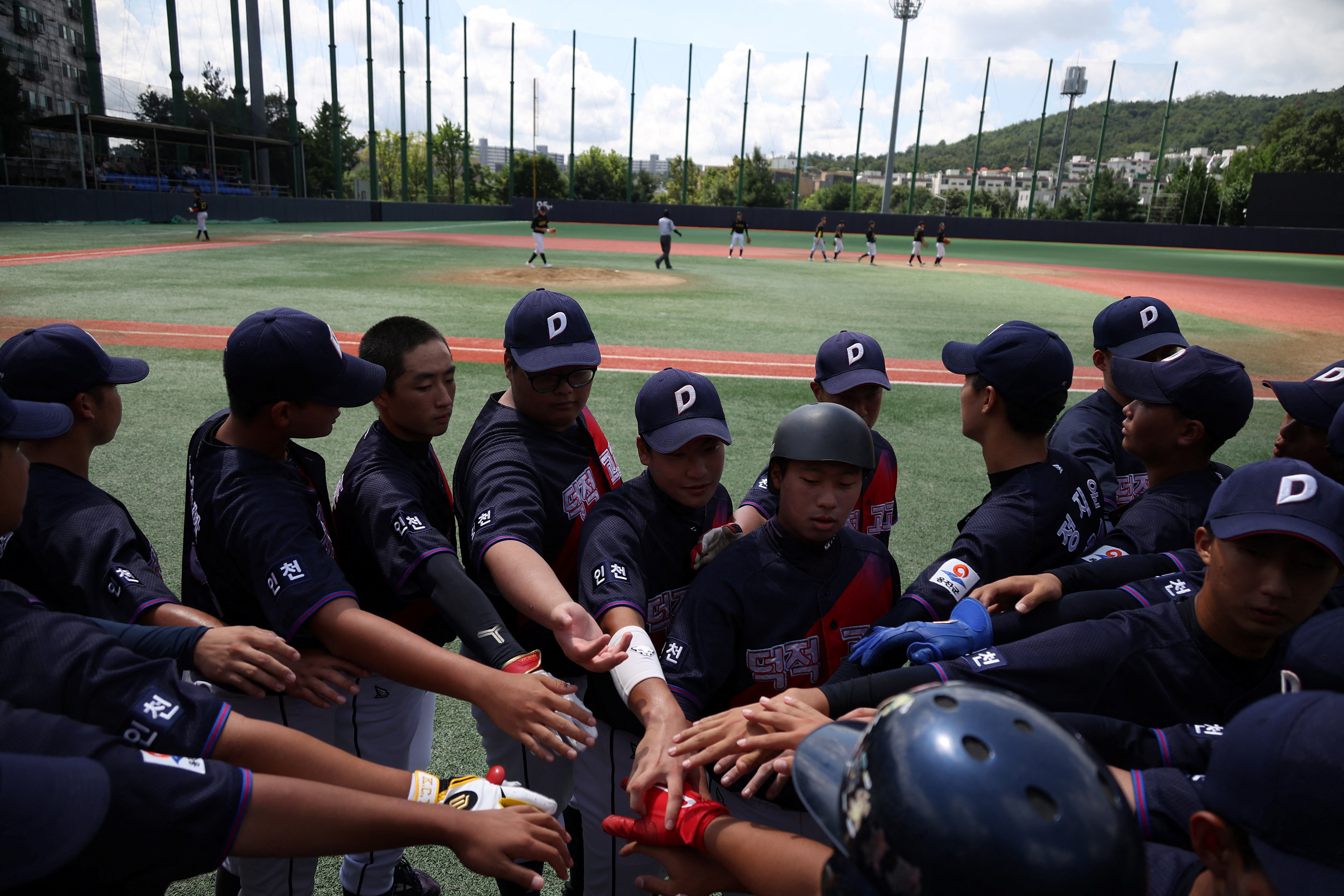 Members of the Deokjeok High School baseball team cheer during their second game of the 51st Bonghwang High School Baseball Tournament in Seoul, South Korea.