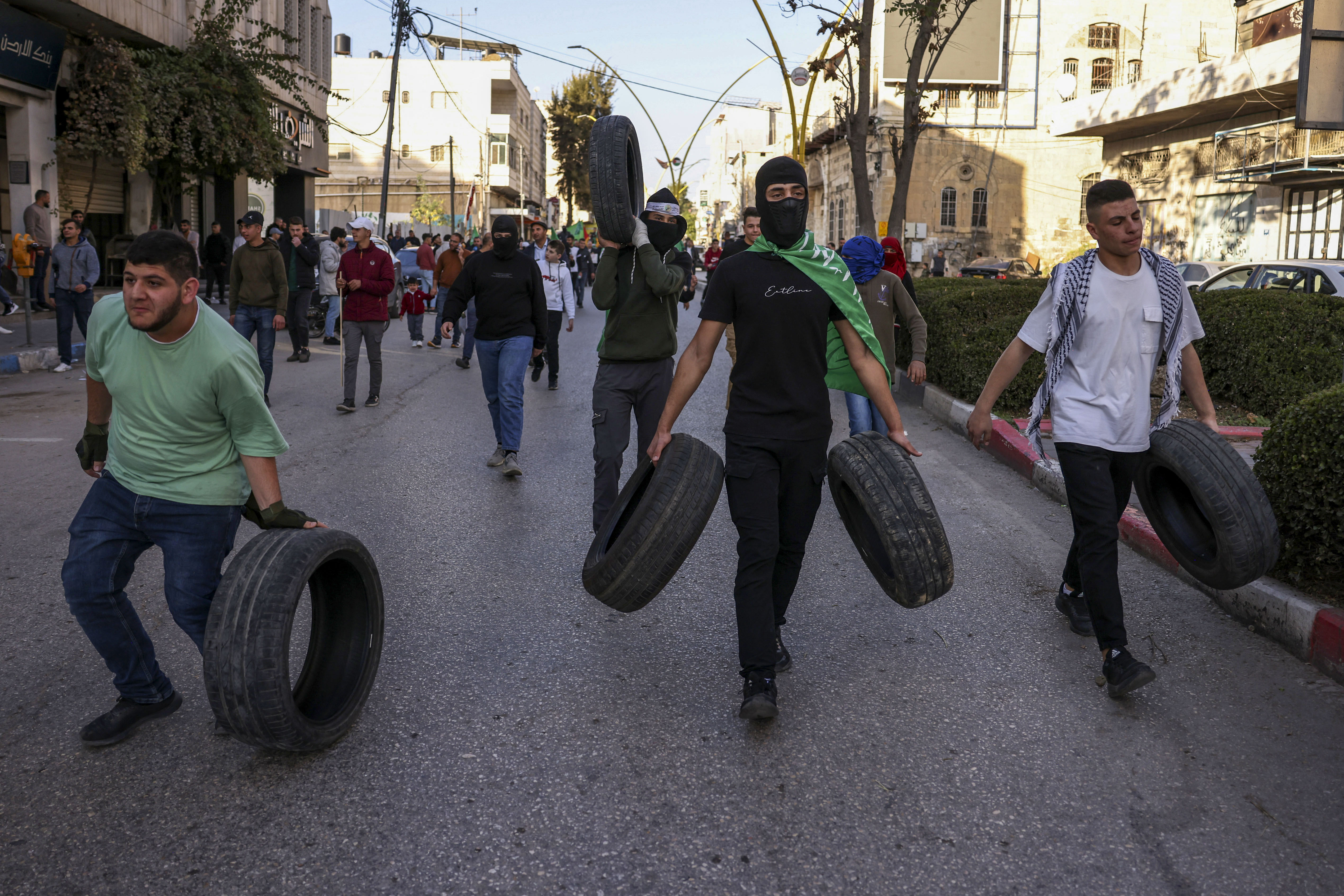 Palestinian protestors carry tyres during a rally supporting the Gaza Strip amid ongoing battles between Israel and the Palestinian movement Hamas, on December 11