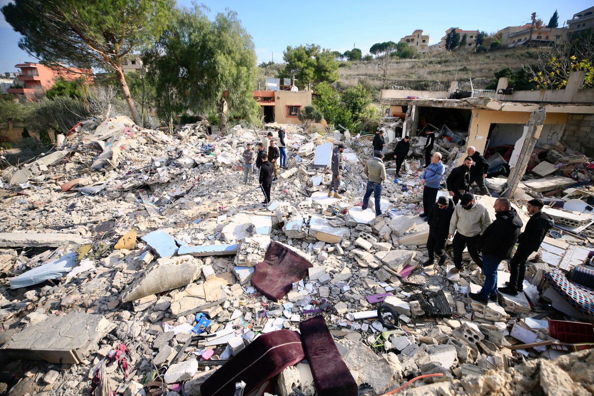 People check the rubble of a building in Bint Jbeil in southern Lebanon near the border with Israel, following Israeli bombardment the previous night, on December 27, 2023