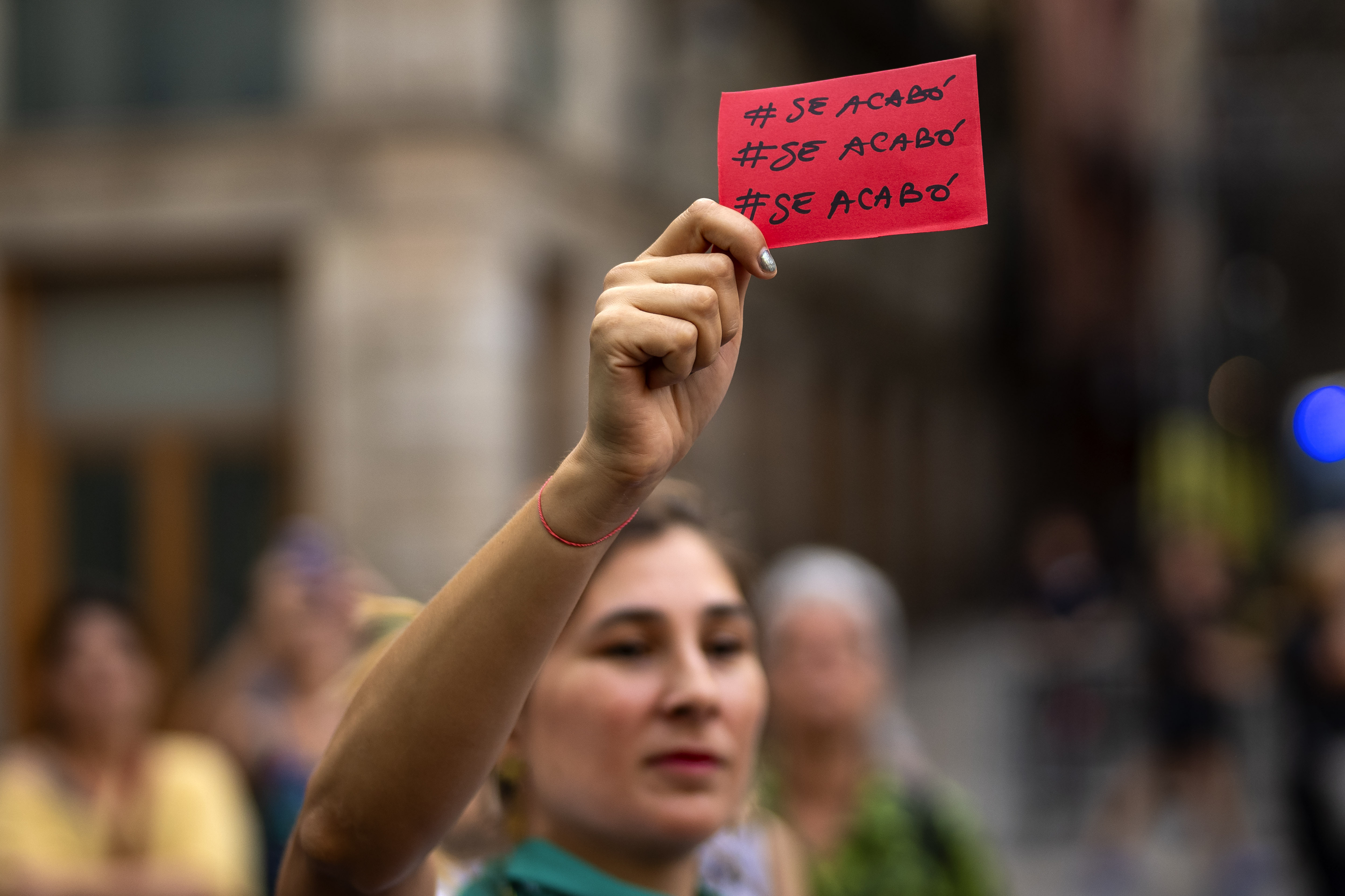 A demonstrator holds a red card reading in Spanish "it is over" during a protest against the President of Spain's soccer federation Luis Rubiales and to support Spain's national women's soccer player Jenni Hermoso in Barcelona, Spain, Monday, Sept. 4, 2023. Spain faces reckoning over sexism in soccer after federation head kisses player at Women's World Cup. (AP Photo/Emilio Morenatti)