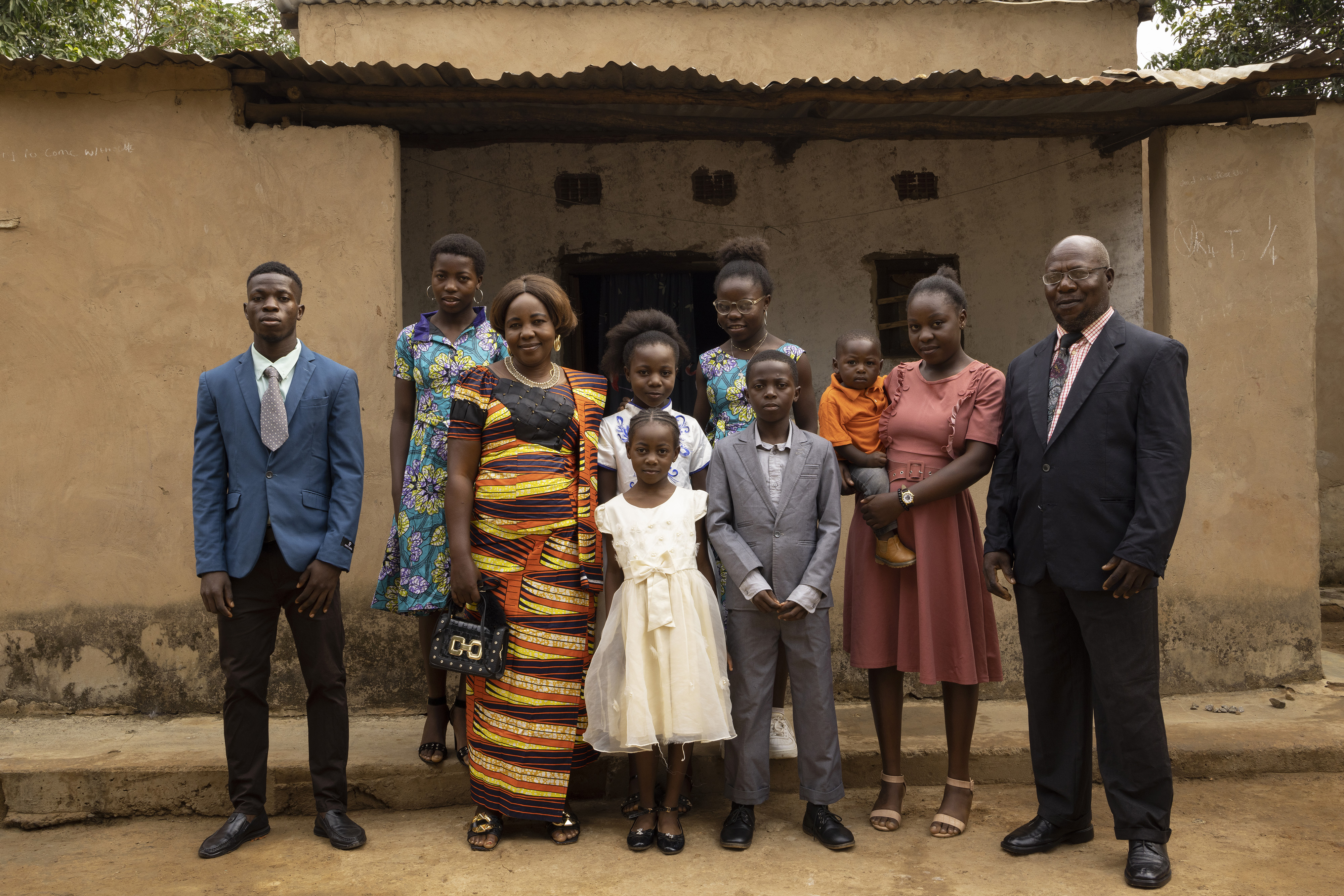 A family of refugees from the DRC stand outside their house in Meheba, Zambia