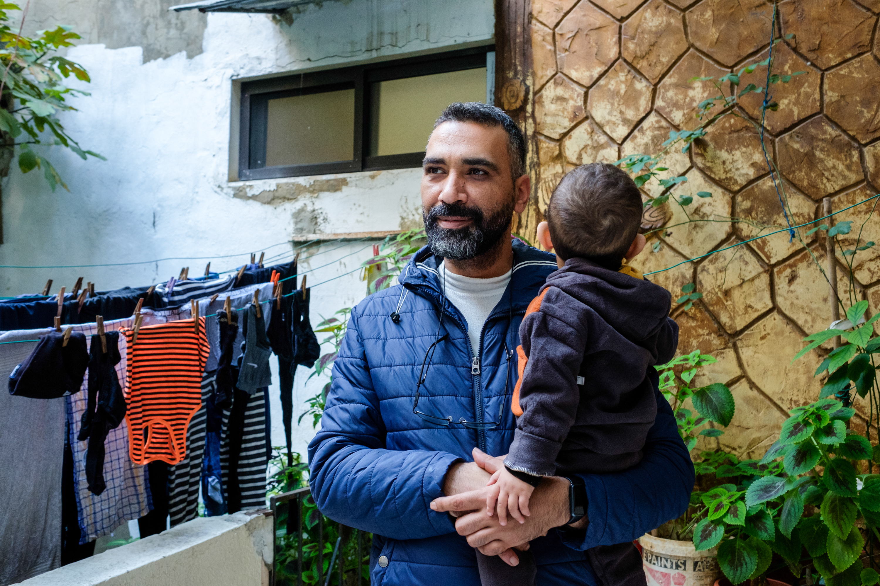 Mohammad Aby Swareh, at the entrance of his mother Fatmeh's home, with his youngest son Jamal.