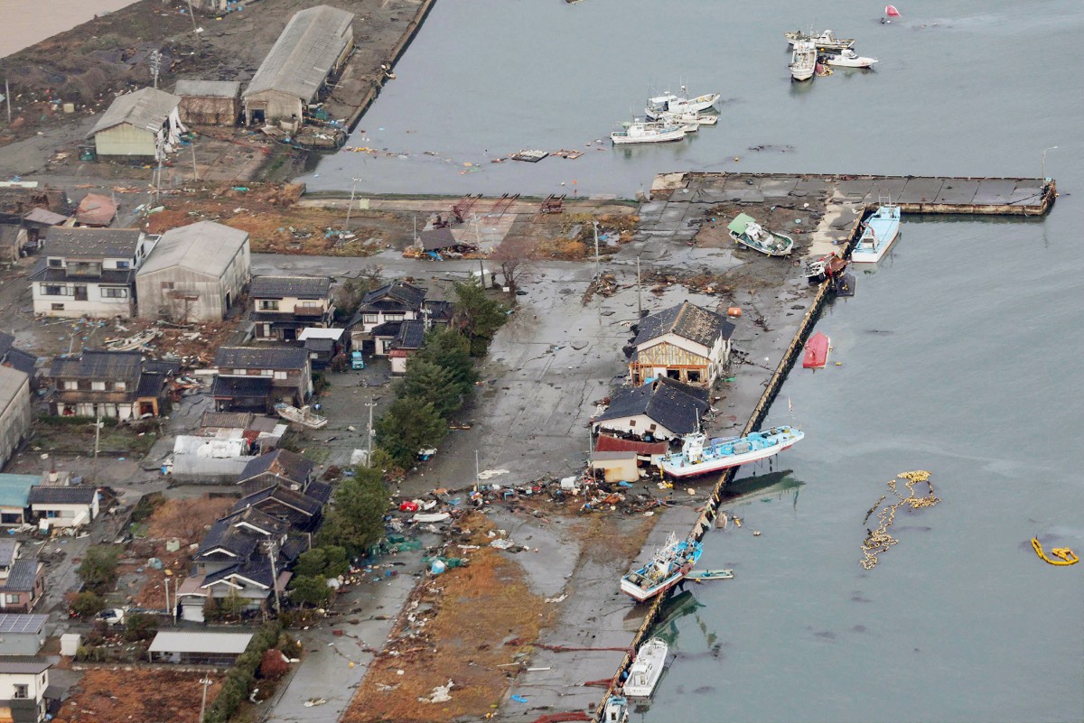 This aerial photo provided by Jiji Press shows capsized boats and others left onshore at the fishing port in the city of Suzu, Ishikawa prefecture.