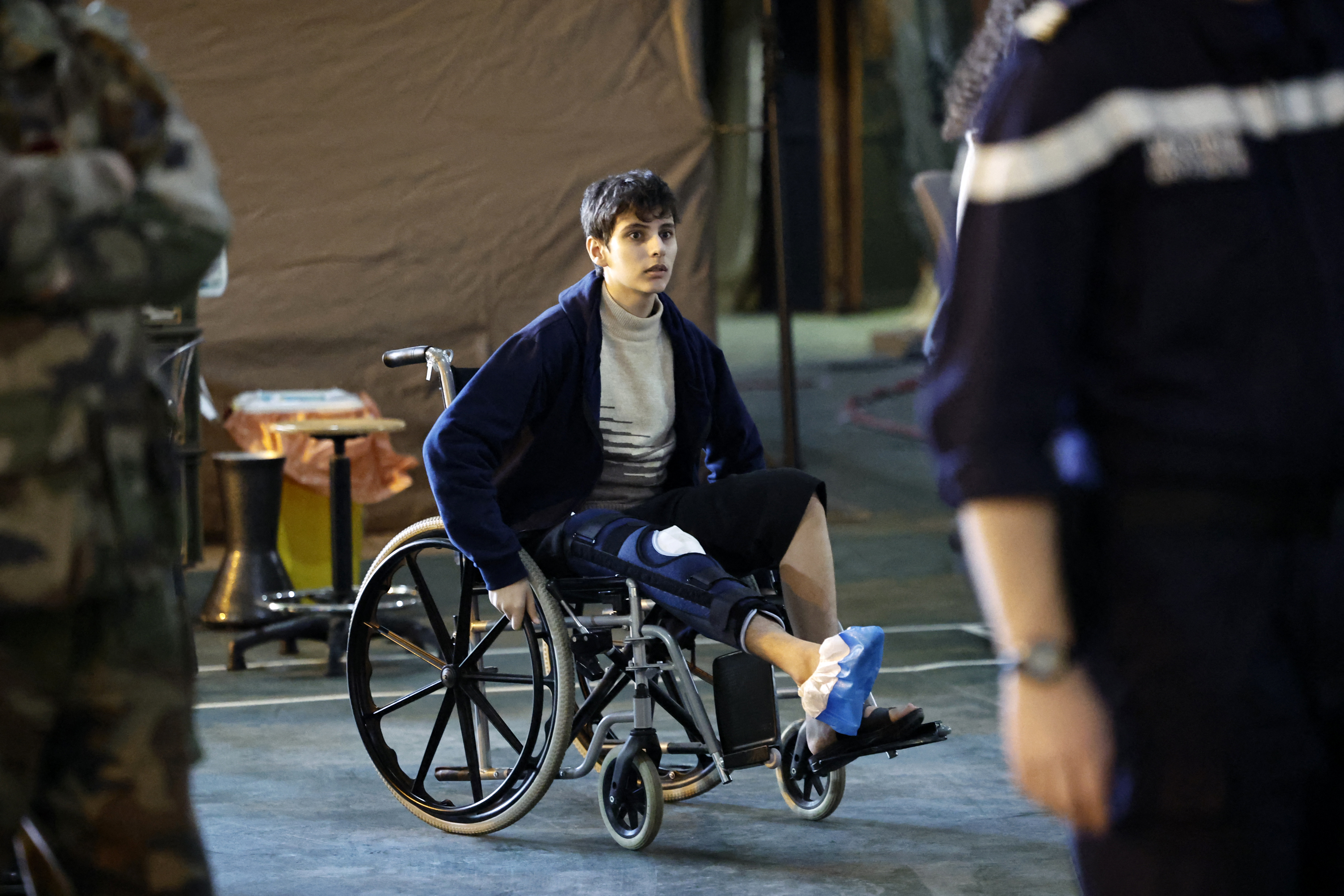 A Palestinian youth pushes his wheelchair onboard the French LHD Dixmude military ship, which serves as a hospital to treat wounded Palestinians, as it docks at the Egyptian port of Al-Arish on January 21