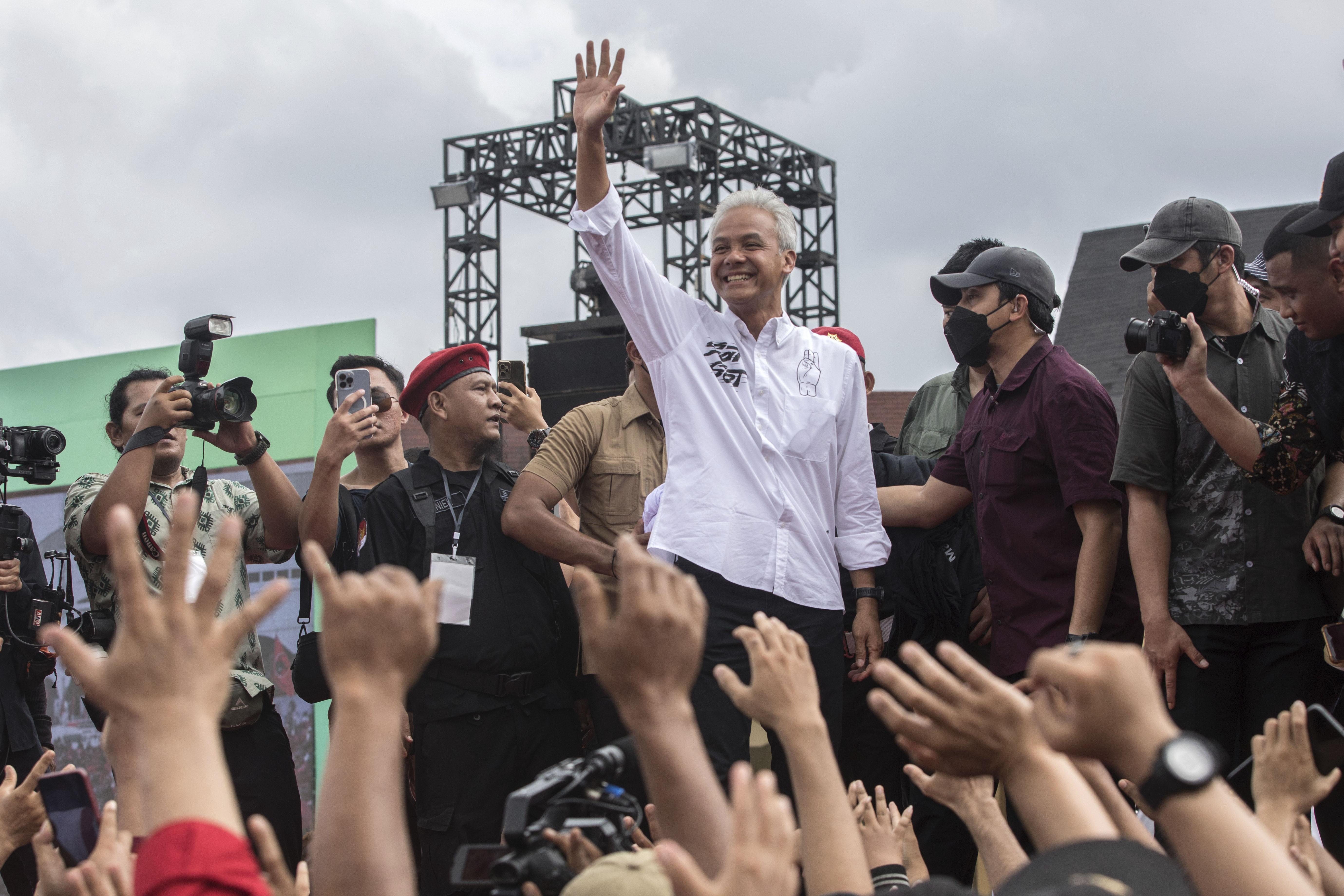 Ganjar Pranowo waving to supporters. He is wearing a white shirt. 