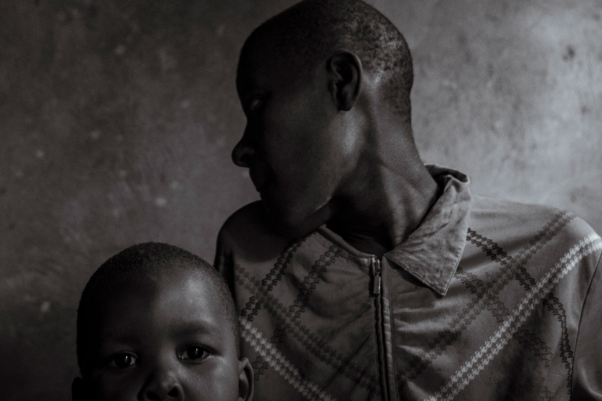 Katherine Muwunguzi, 20, (right) sits with her mother, Joy Nangobi, and her son, Edwin [Christopher Hopkins/Al Jazeera]