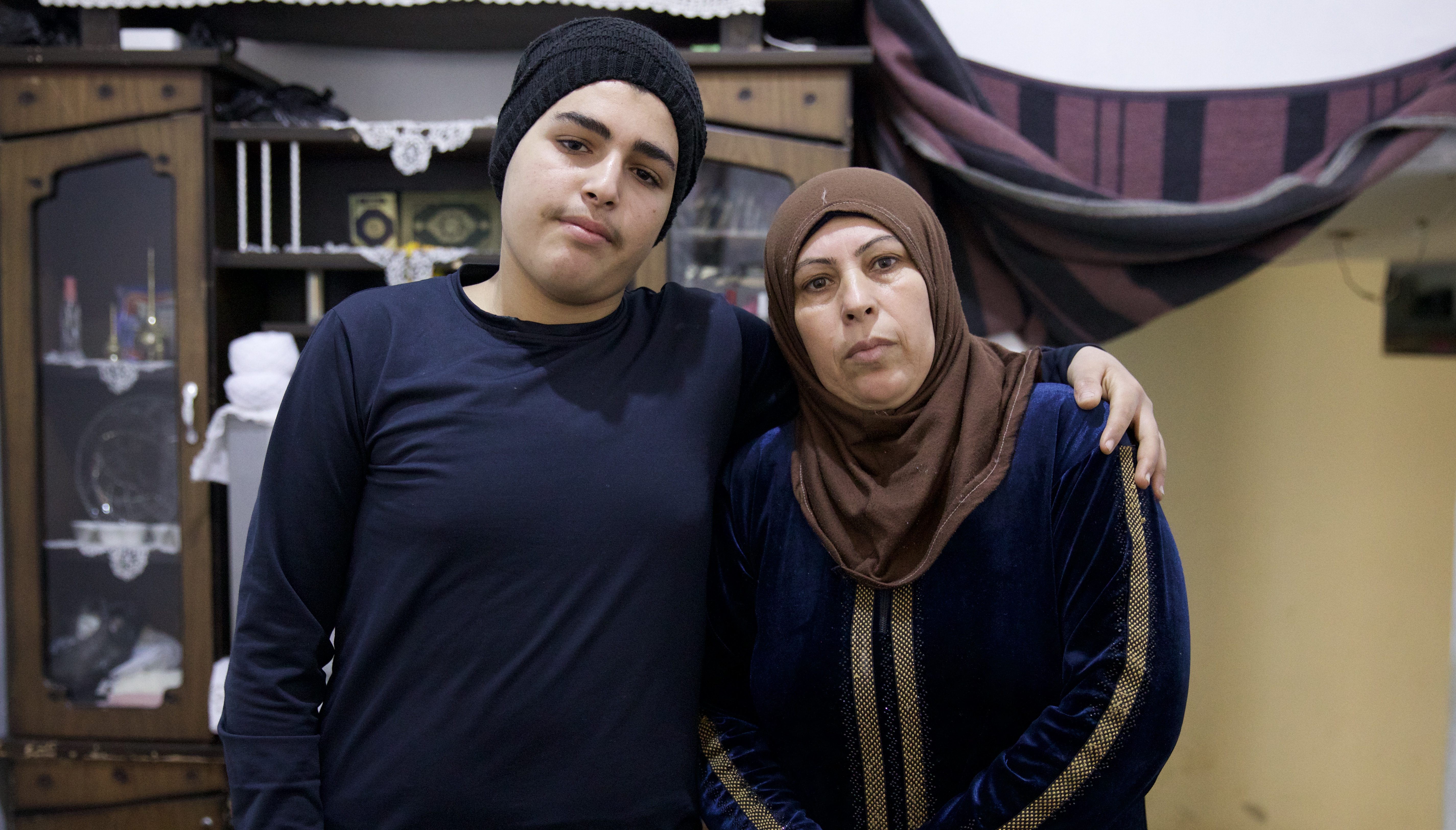 Ali stands with his arm around his mother