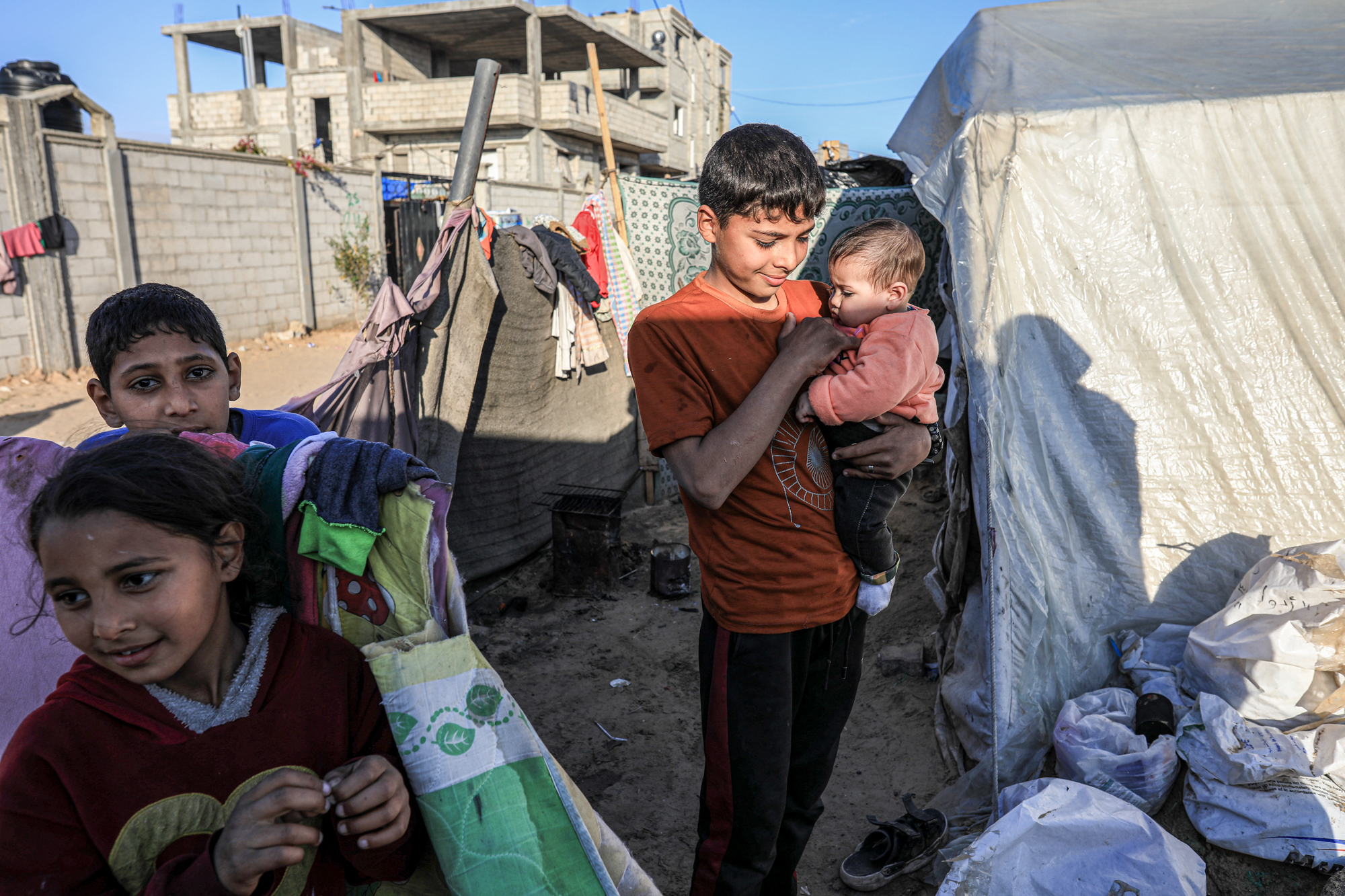 Mohamed holds Toleen outside their tent