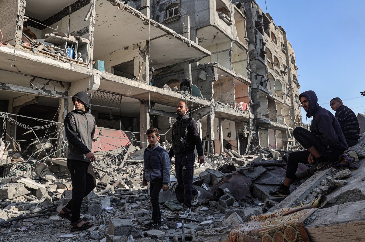 Palestinians walk amid debris