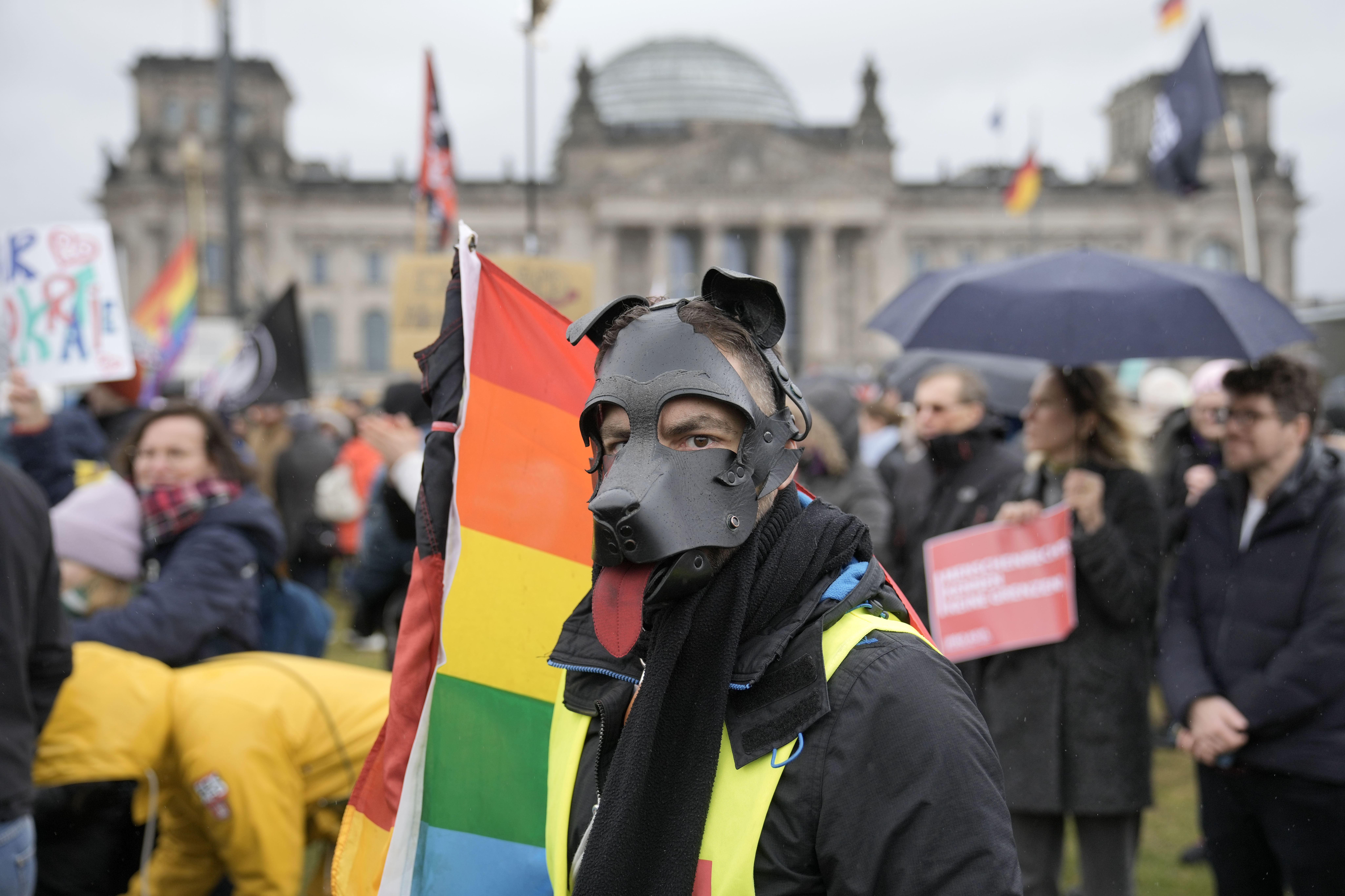 A protestor wears a dog mask in front of Germany's parliament Reichstag during a demonstration against the AfD party and right-wing extremism in Berlin, Germany, Saturday, Feb. 3