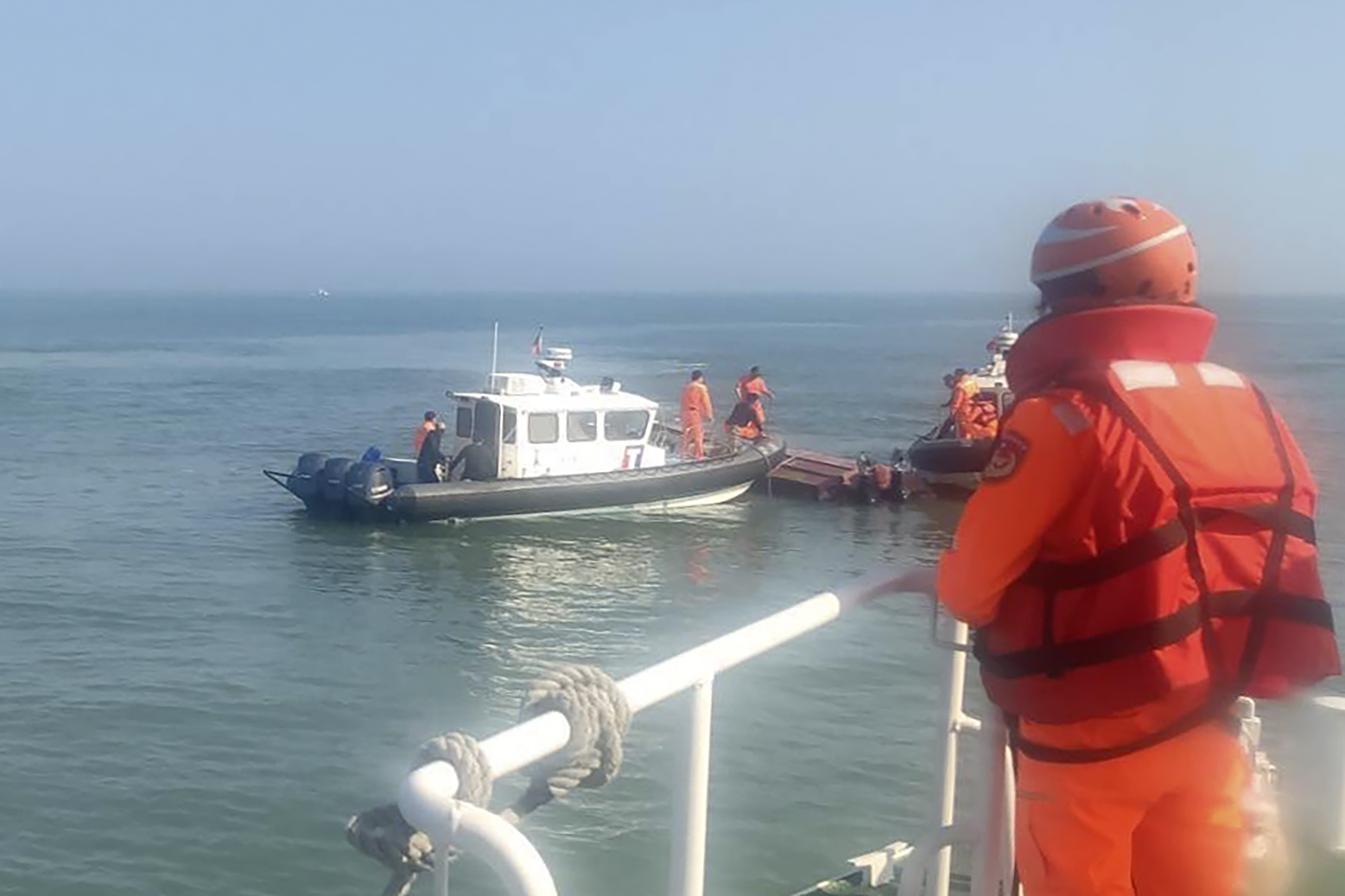 In this handout photograph provided by Taiwan Coast Guard Administration, Taiwanese coast guards inspect a vessel that capsized during a chase off the coast of Kinmen archipelago in Taiwan, Wednesday, February 14, 2024.