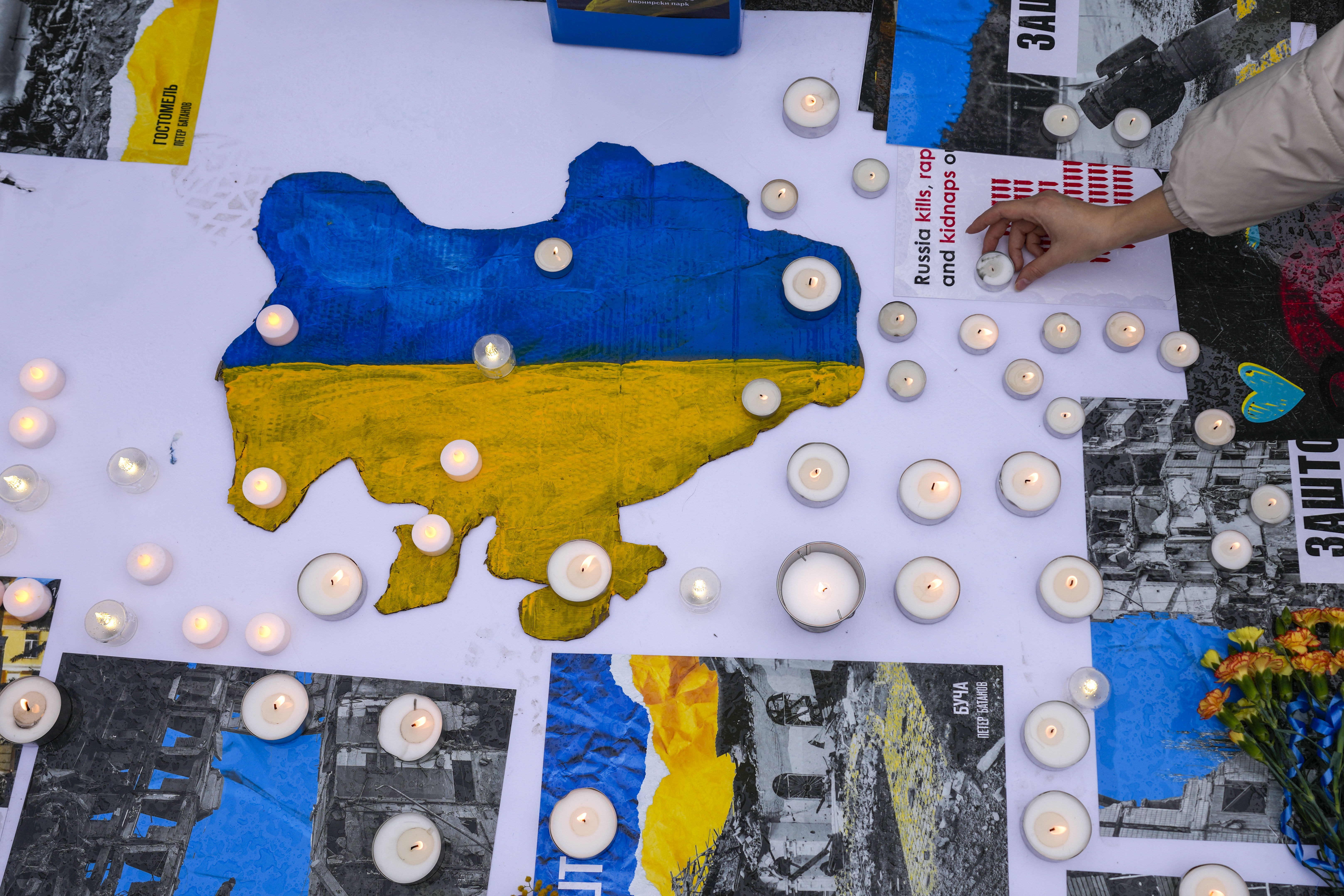 A woman lights a candle during a protest to mark two years since Russia's full-scale invasion on Ukraine in Belgrade, Serbia, Saturday