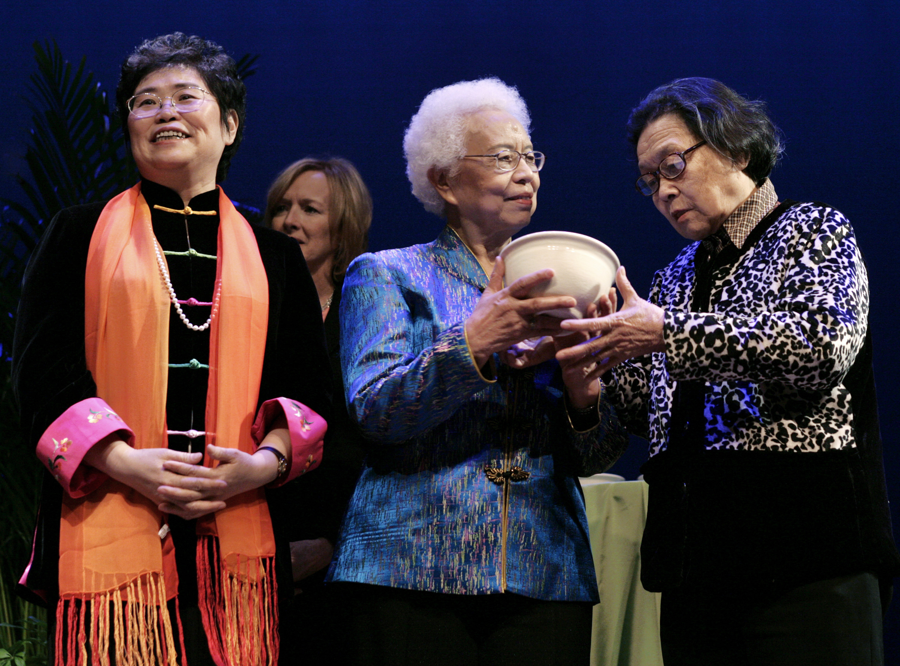 Gao Yaojie receiving the ital Voices annual award in 2007, She is standing on stage on the right. On the left is Xie Lihua, founder and editor of Rural Women Knowing All magazine and secretary general of the Development Center for Rural Women in Beijing, and Wang Xingjuan (centre), founder of a non-governmental women's research institute.