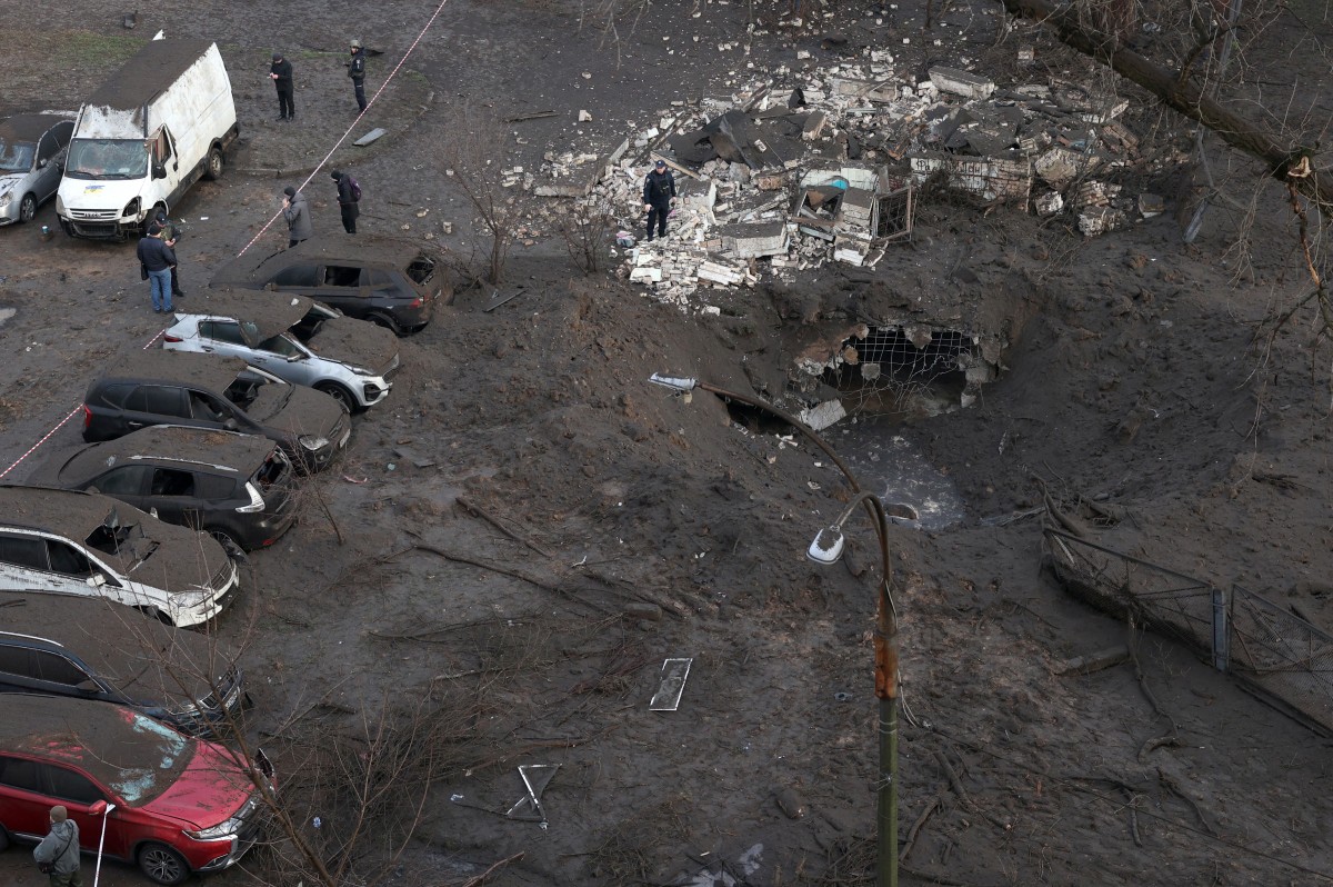 Police officers inspect a crater caused by an explosion after a missile attack in Kyiv