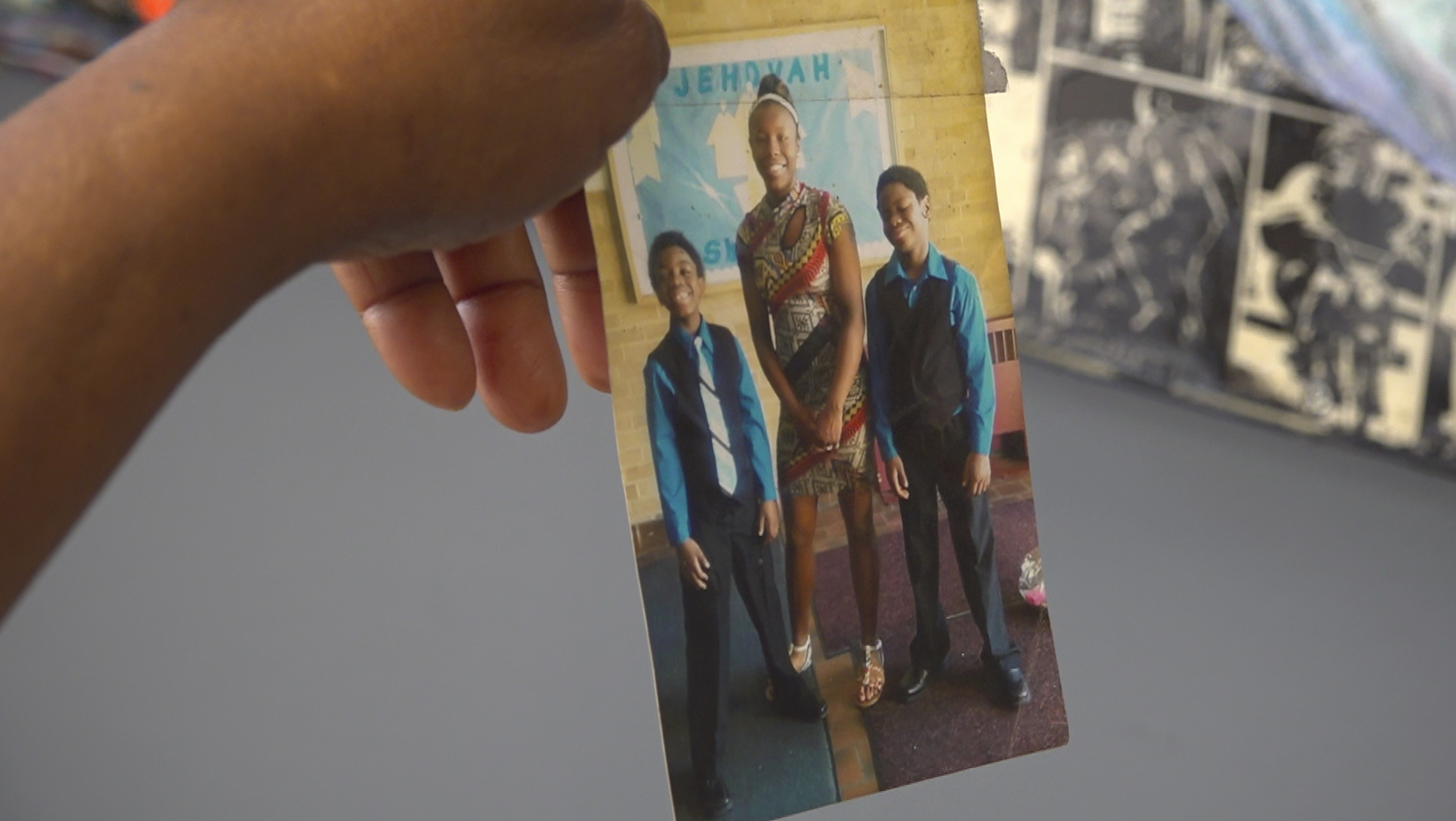 Nadine Young holds up a photo of Ta'Kiya Young with two of her relatives