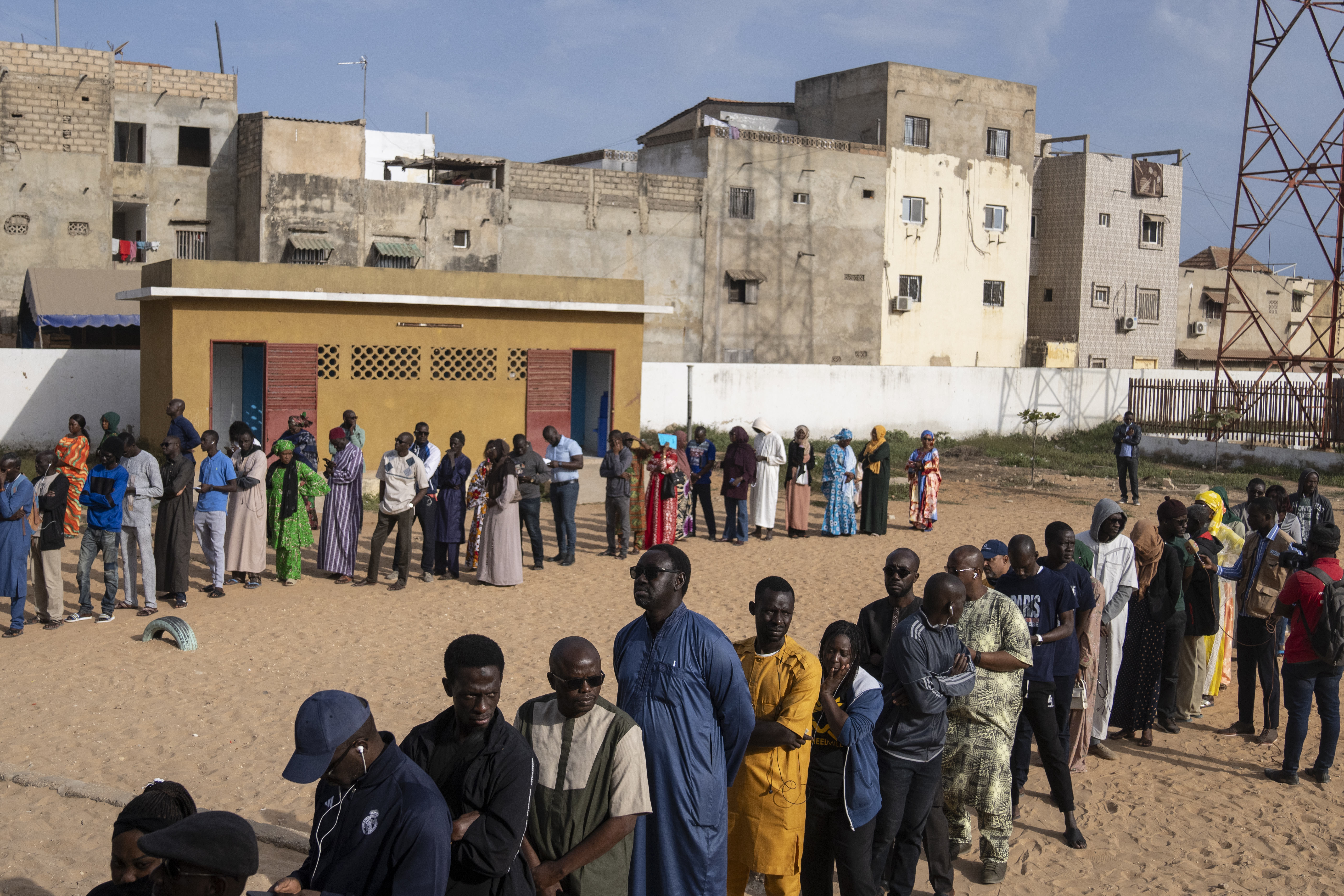 People wait to cast their votes outside a polling station during the presidential elections, in Dakar, Senegal, Sunday, March 24