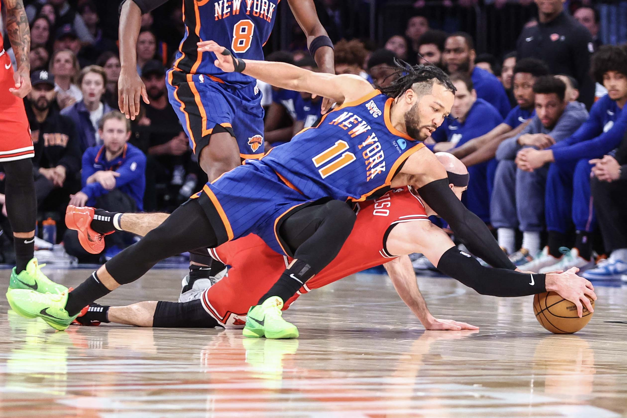 Jalen Brunson (11) and Chicago Bulls guard Alex Caruso (6) fight for a loose ball.
