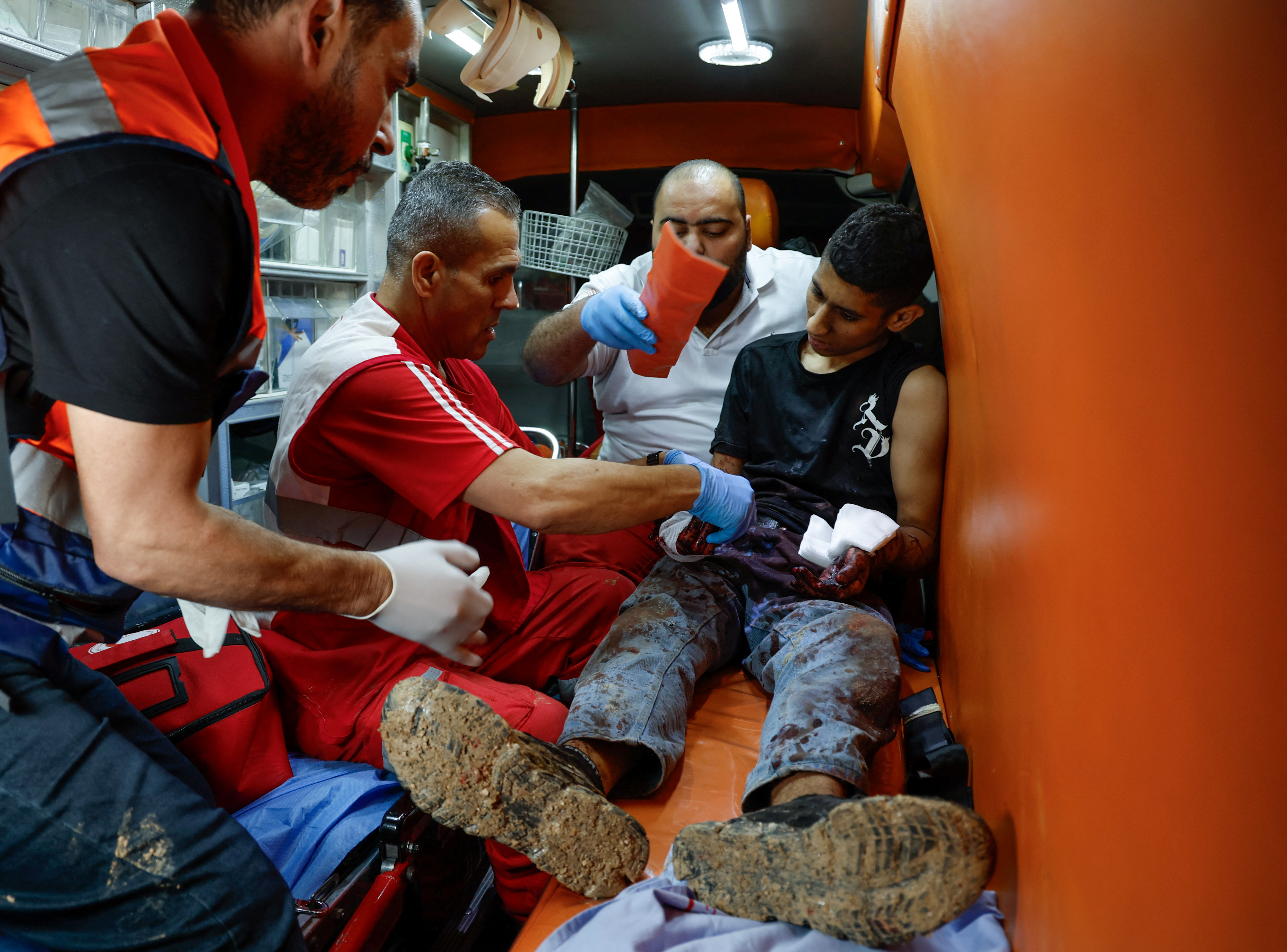 Paramedics assist a wounded man inside an ambulance, in Tulkarm, in the Israeli-occupied West Bank, April 19, 2024