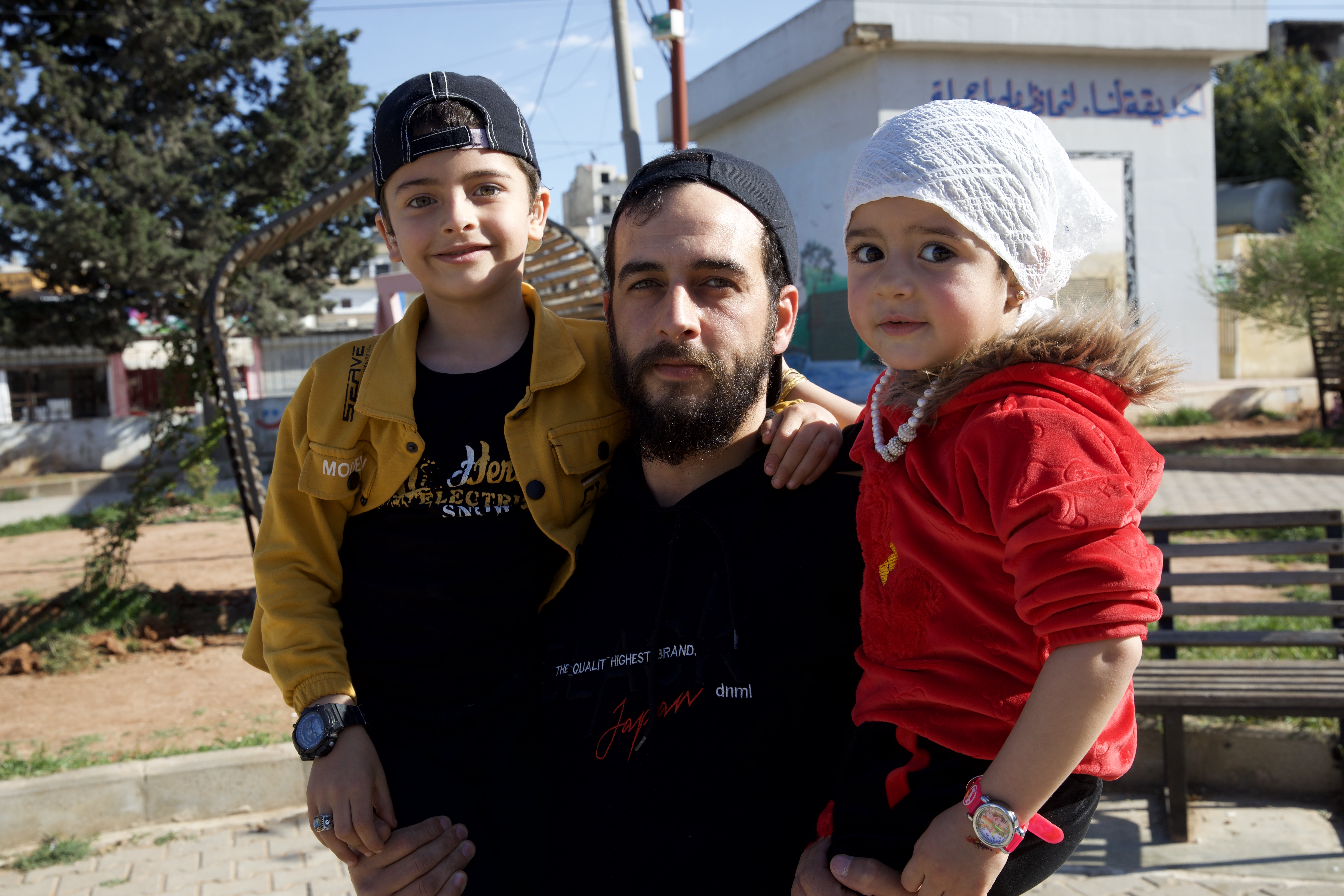 Khalid holding the two kids for a photo in Idlib, Syria