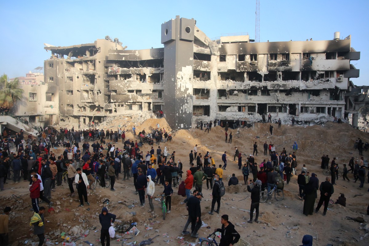 Palestinians gather around the burned and destroyed Al-Shifa Hospital