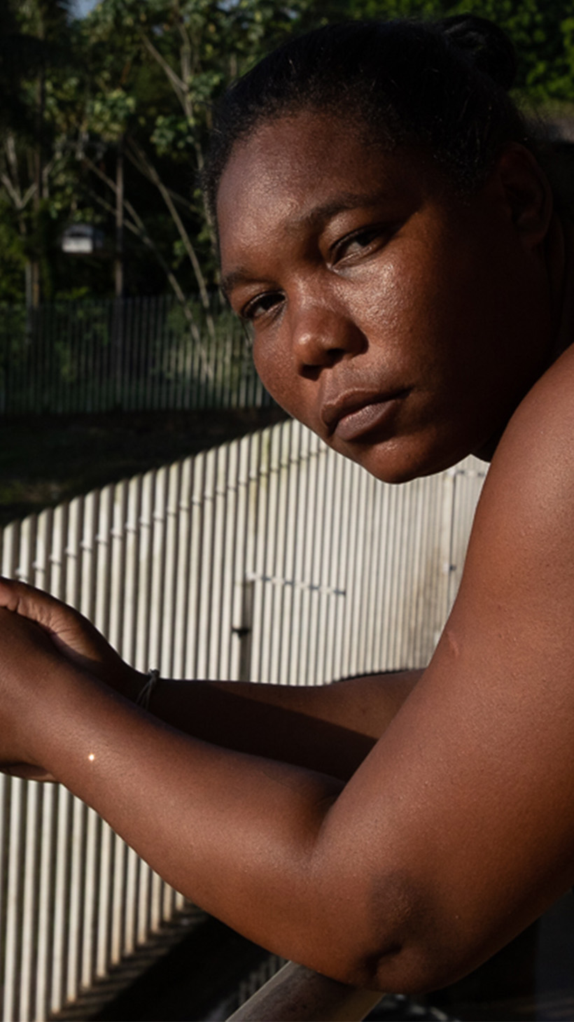 Consuela Manyoma leans against a railing outside the Crystal Coliseum