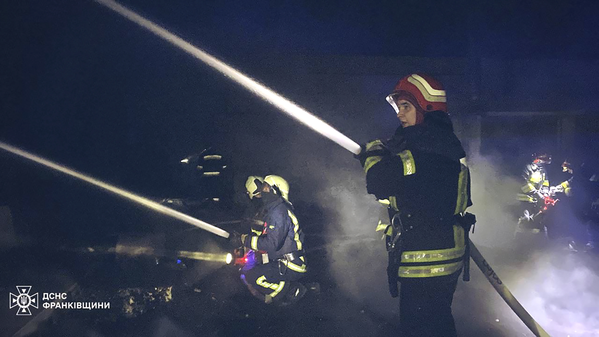 Emergency services personnel work to extinguish a fire