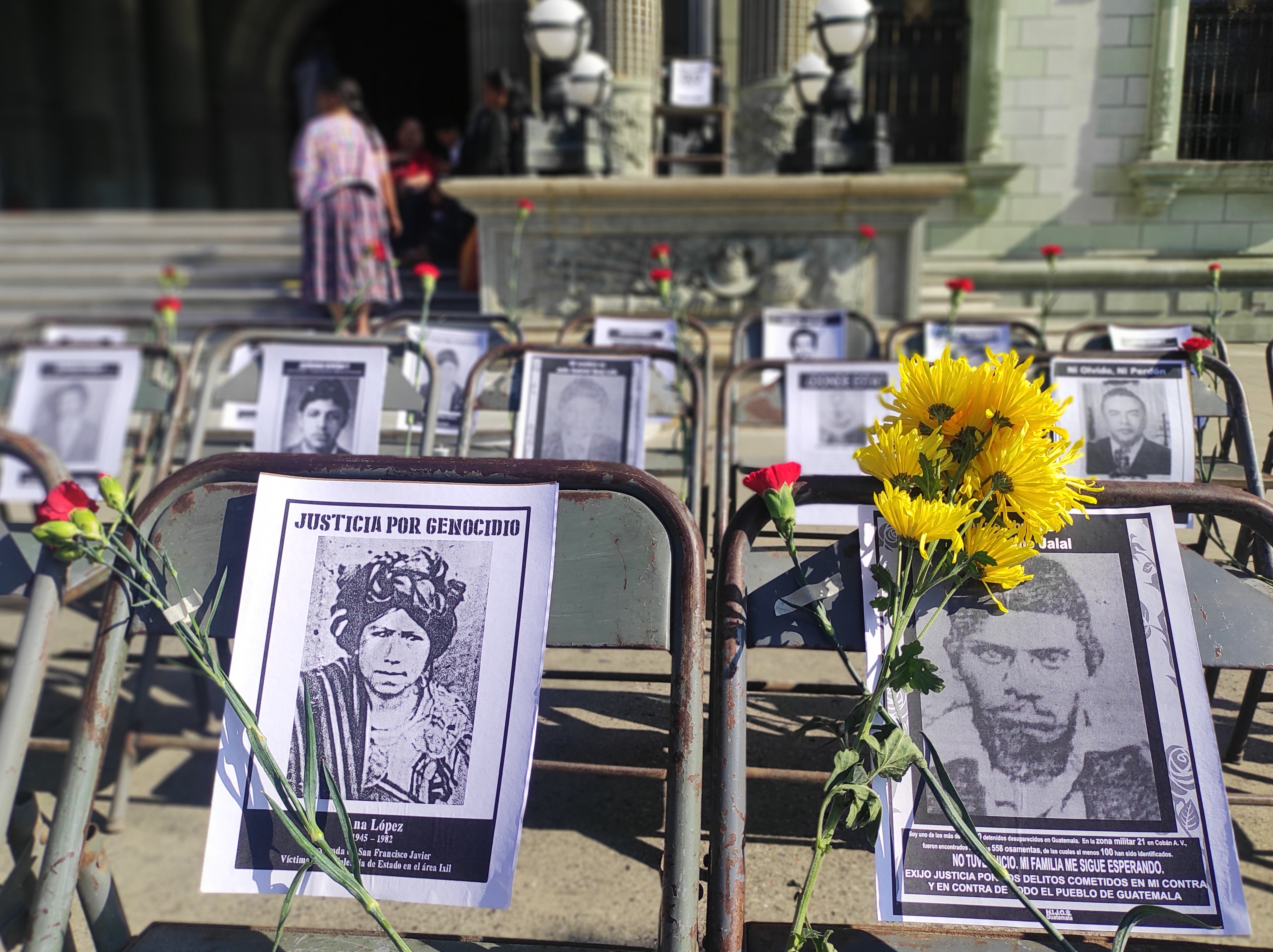 Black-and-white photos are propped up outside of a courthouse in Guatemala City, Guatemala