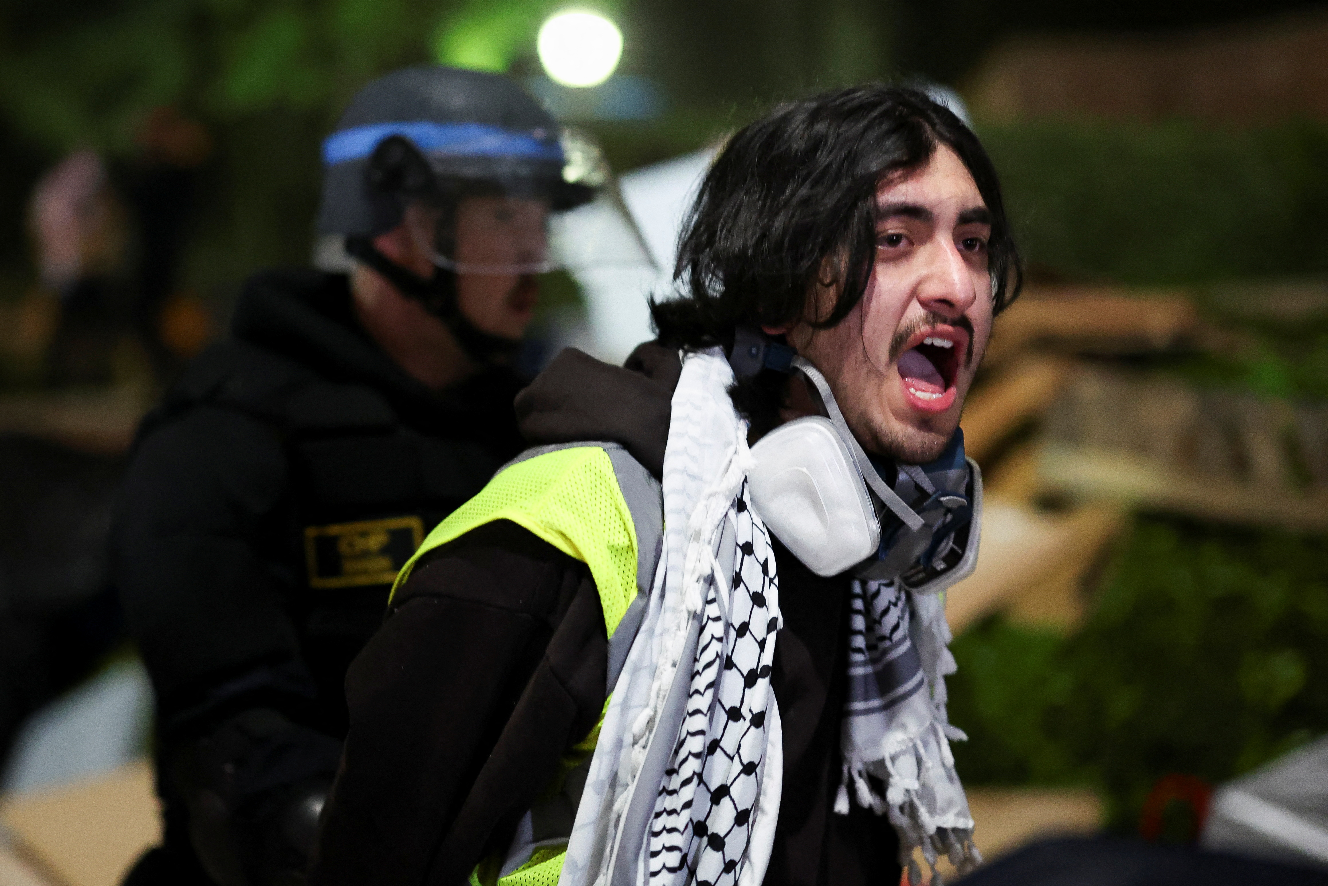 A protester reacts next to a law enforcement officer at the University of California Los Angeles (UCLA)