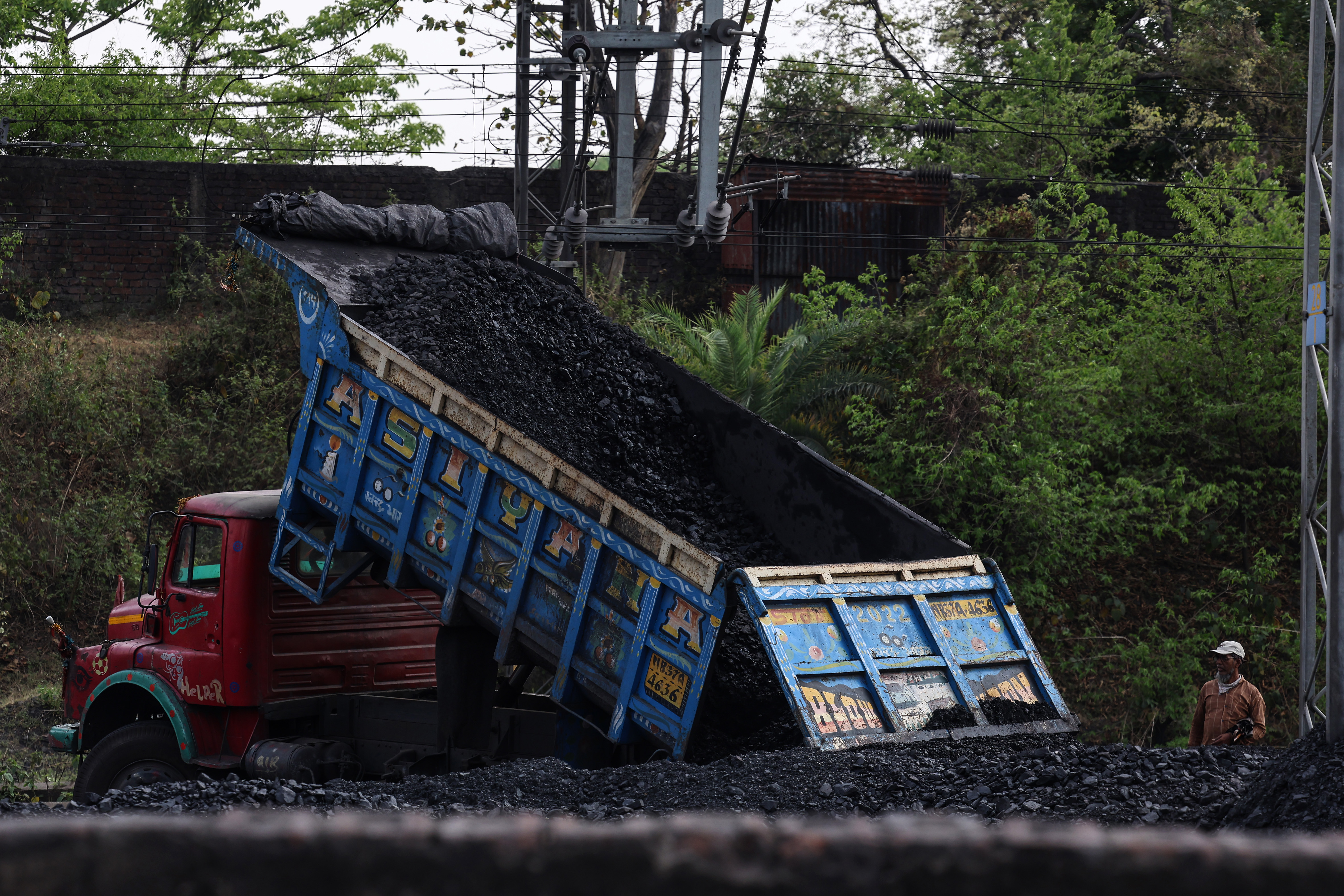 A truck unloads coal at a coal siding rail track near the railway station in Barabani, West Bengal