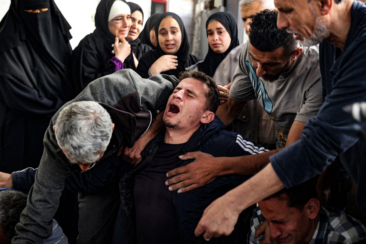 EDITORS NOTE: Graphic content / A Palestinian man mourns relatives killed in Israeli bombing in Rafah in the southern Gaza Strip on April 20, 2024, amid the ongoing conflict between Israel and the Hamas movement. (Photo by AFP)