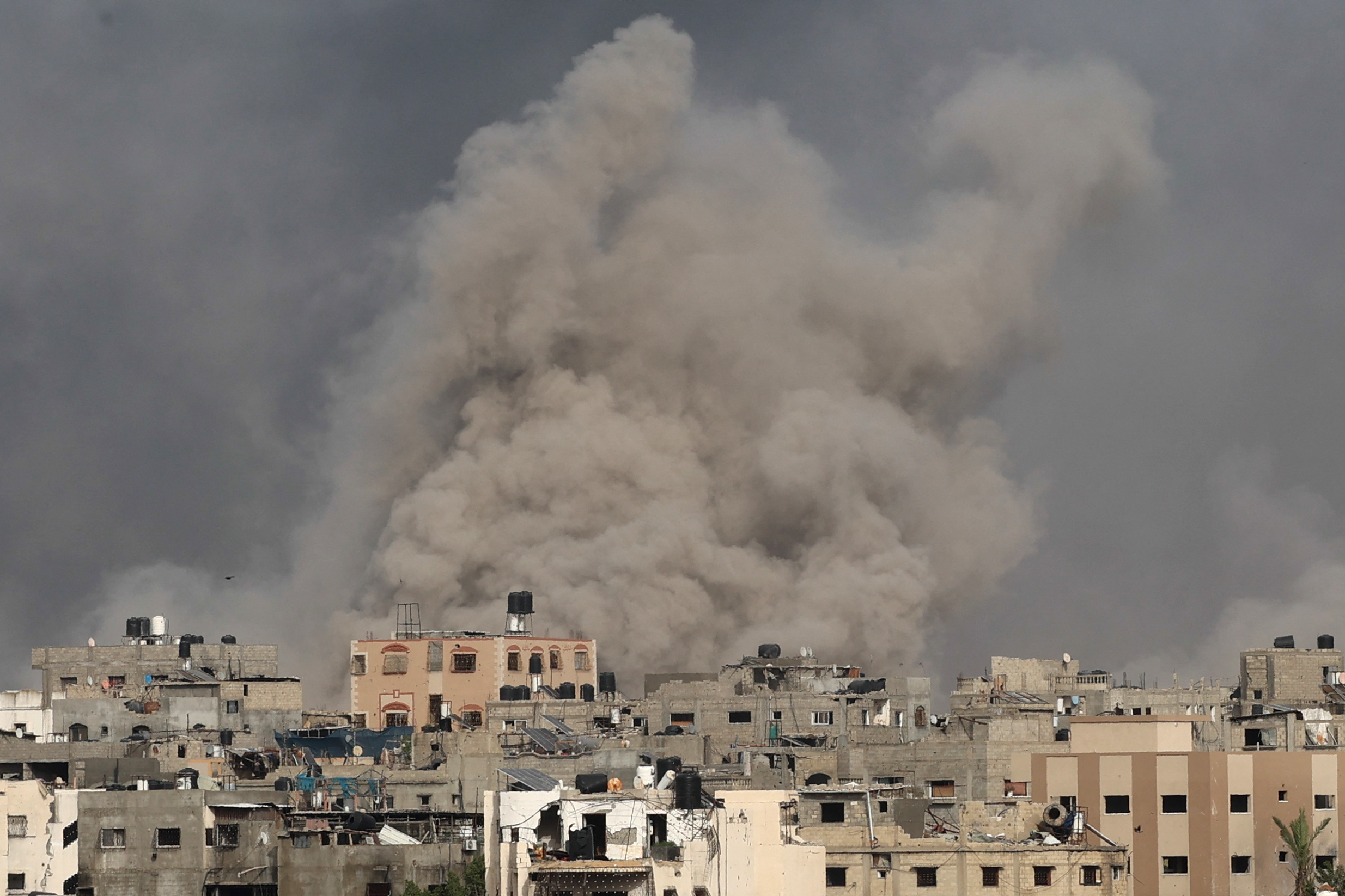 plumes of smoke rising from a city