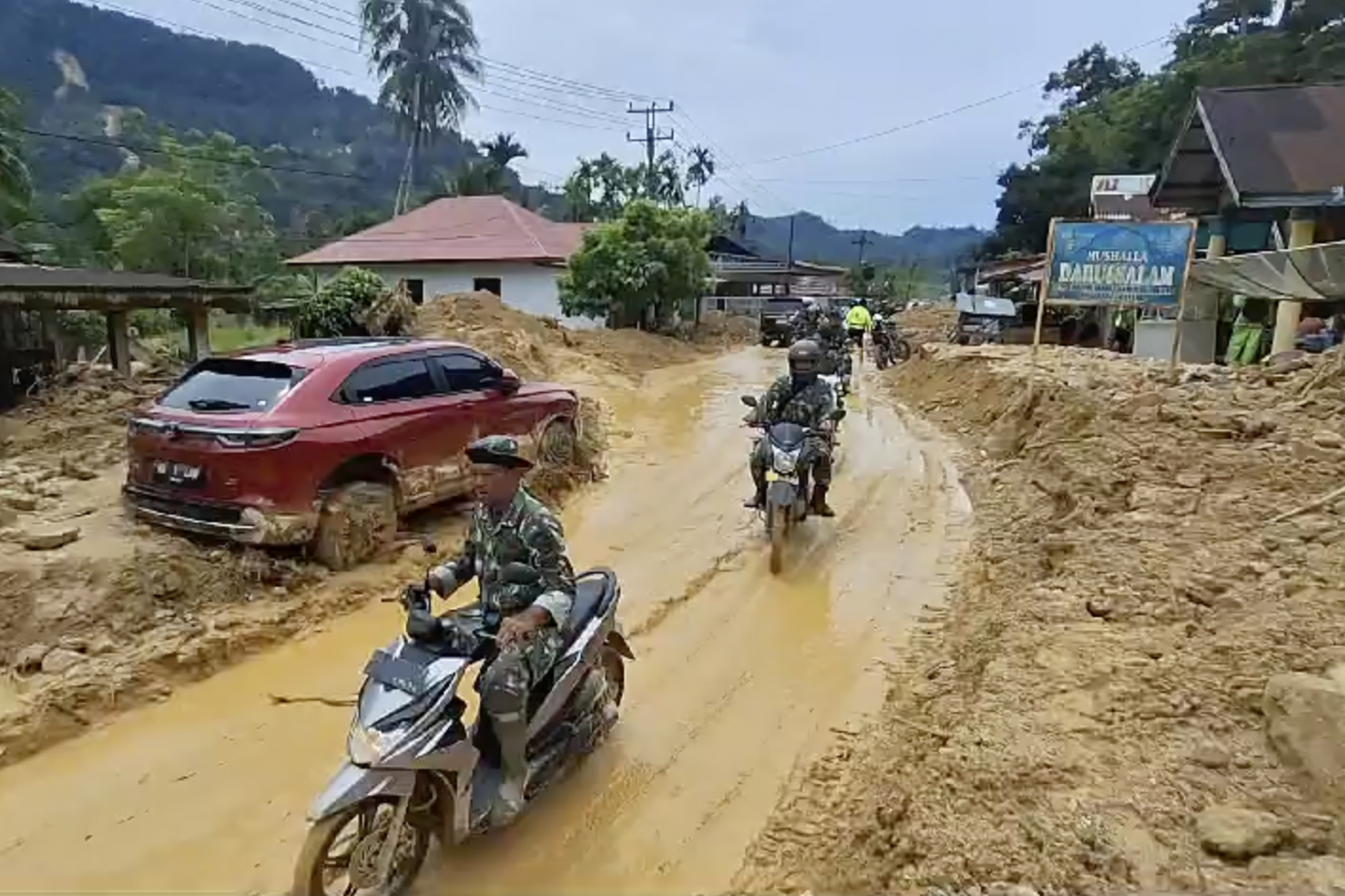 Soldiers ride motor bikes in a village affected by flash flood in Langgai, West Sumatra, Indonesia, March 10, 2024