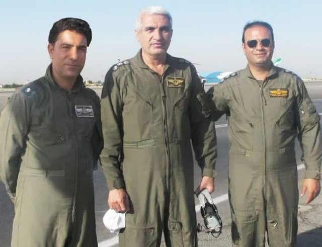 Three men in flight coveralls looking at the camera