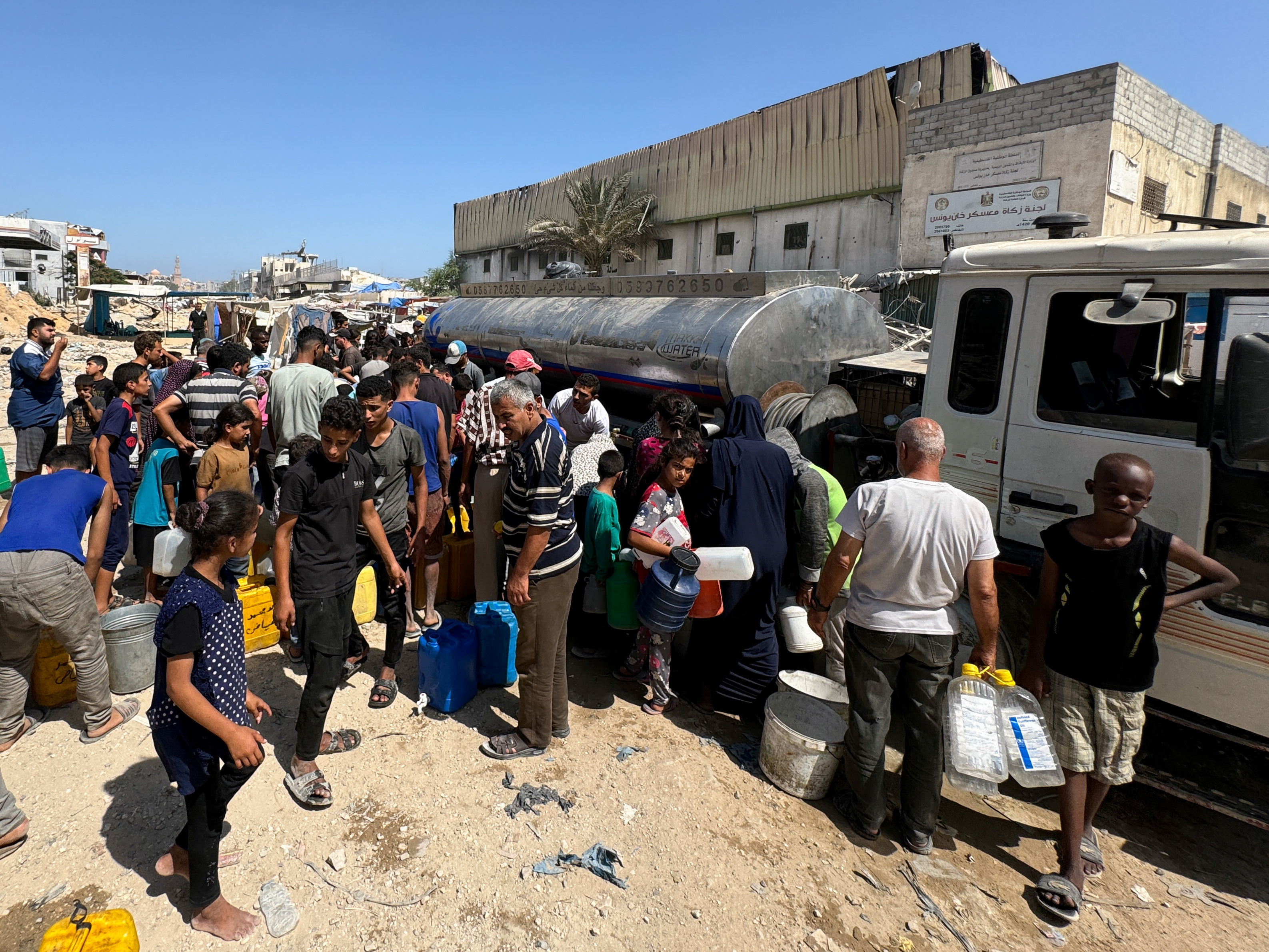 Palestinians gather to fill containers with water amid shortages as Israel-Hamas conflict continues, in Khan Younis