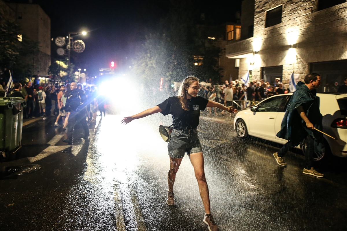 a person walks through water sprayed in the street