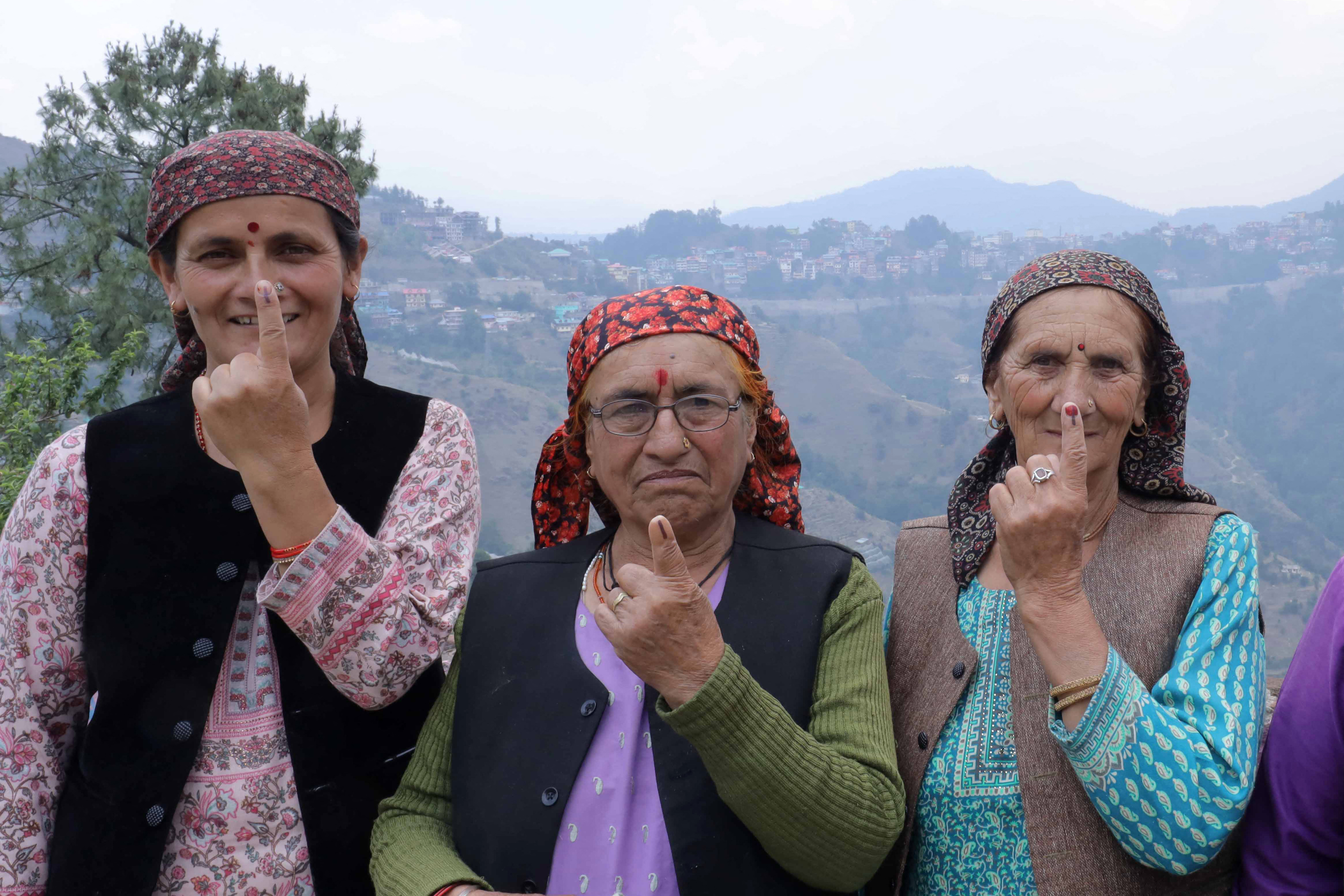 Voters show their indelible ink marks after casting their ballots at a polling station during the seventh and final phase of voting in country's general election in Devrighat village on the outskirts of Shimla in India's Himachal Pradesh state on June 1, 2024.