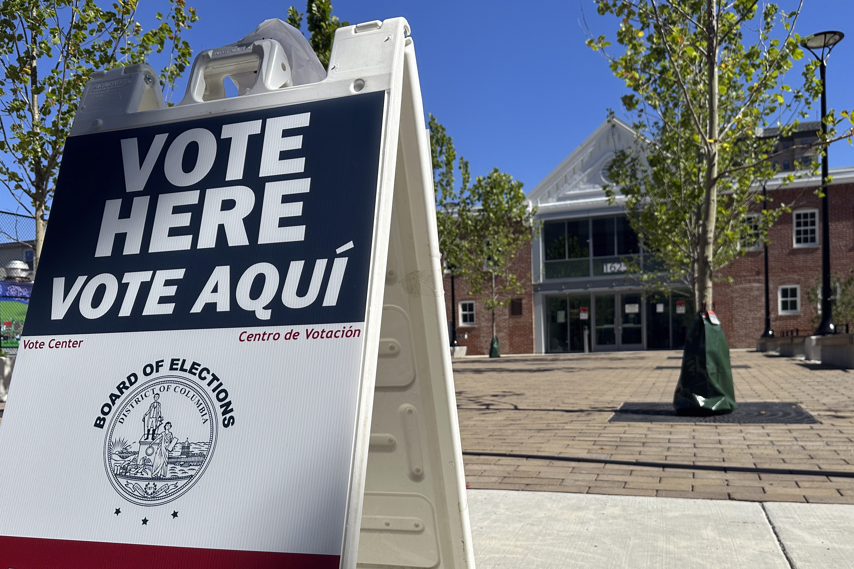 A V-shaped sign outside a polling station in the US reads: "Vote here. Vote Aqui."