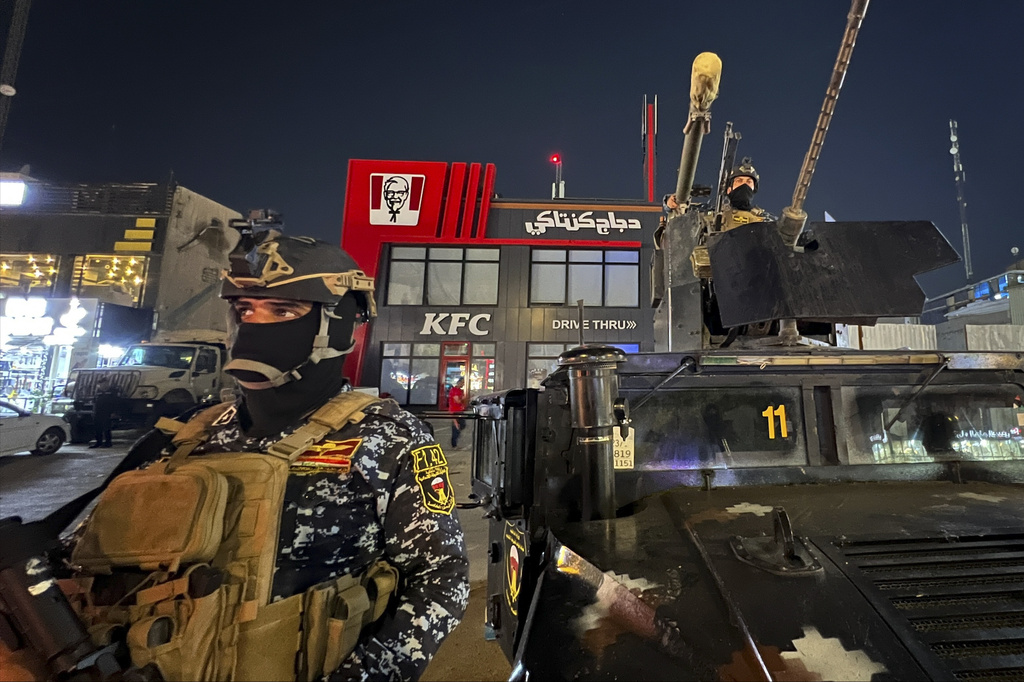 Iraqi security forces stand guard in front of Kentucky Fried Chicken restaurant in Baghdad