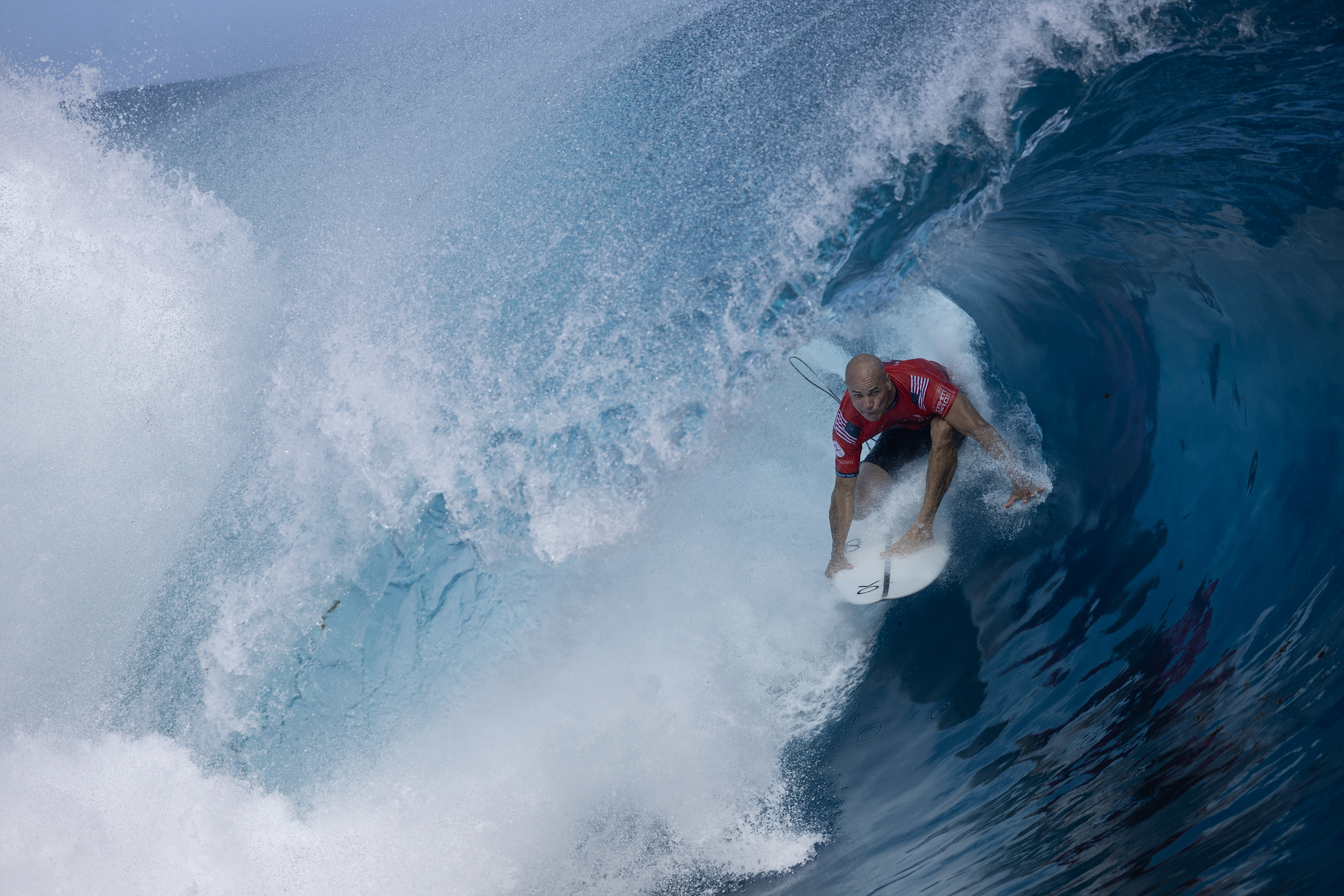 Surfers gets barreled in wave.