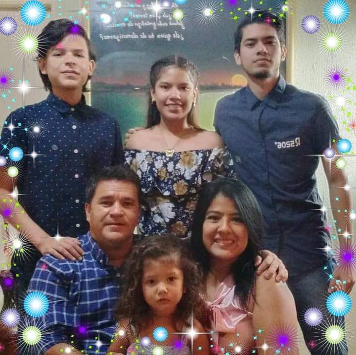 Two sons, two daughters, a mother and a father pose for a family photo, framed in sparkle graphics.