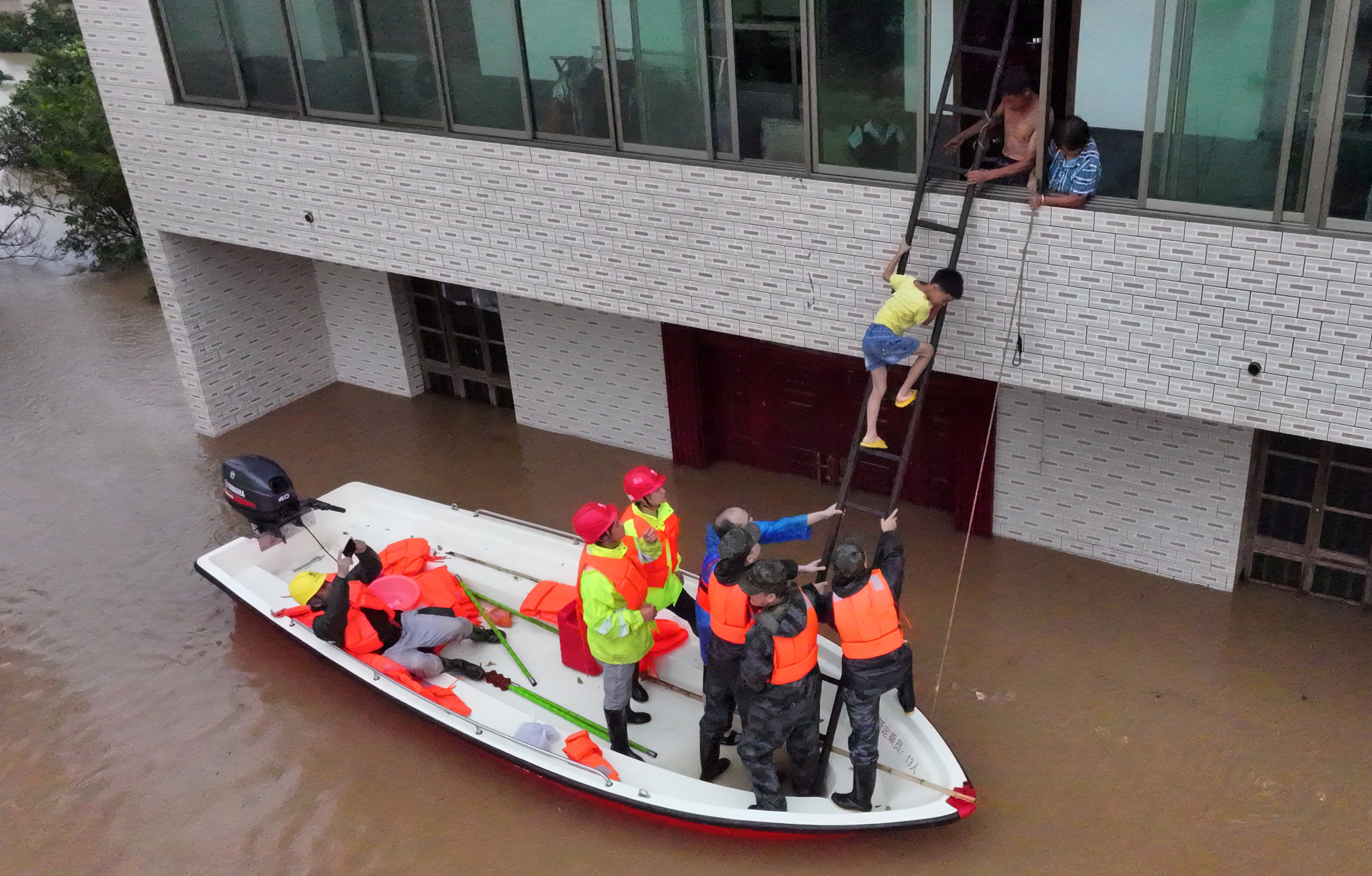 A drone view shows rescue workers evacuating residents stranded by floodwaters following heavy rainfall in the region, in Caoshi town of Hengyang, Hunan province,