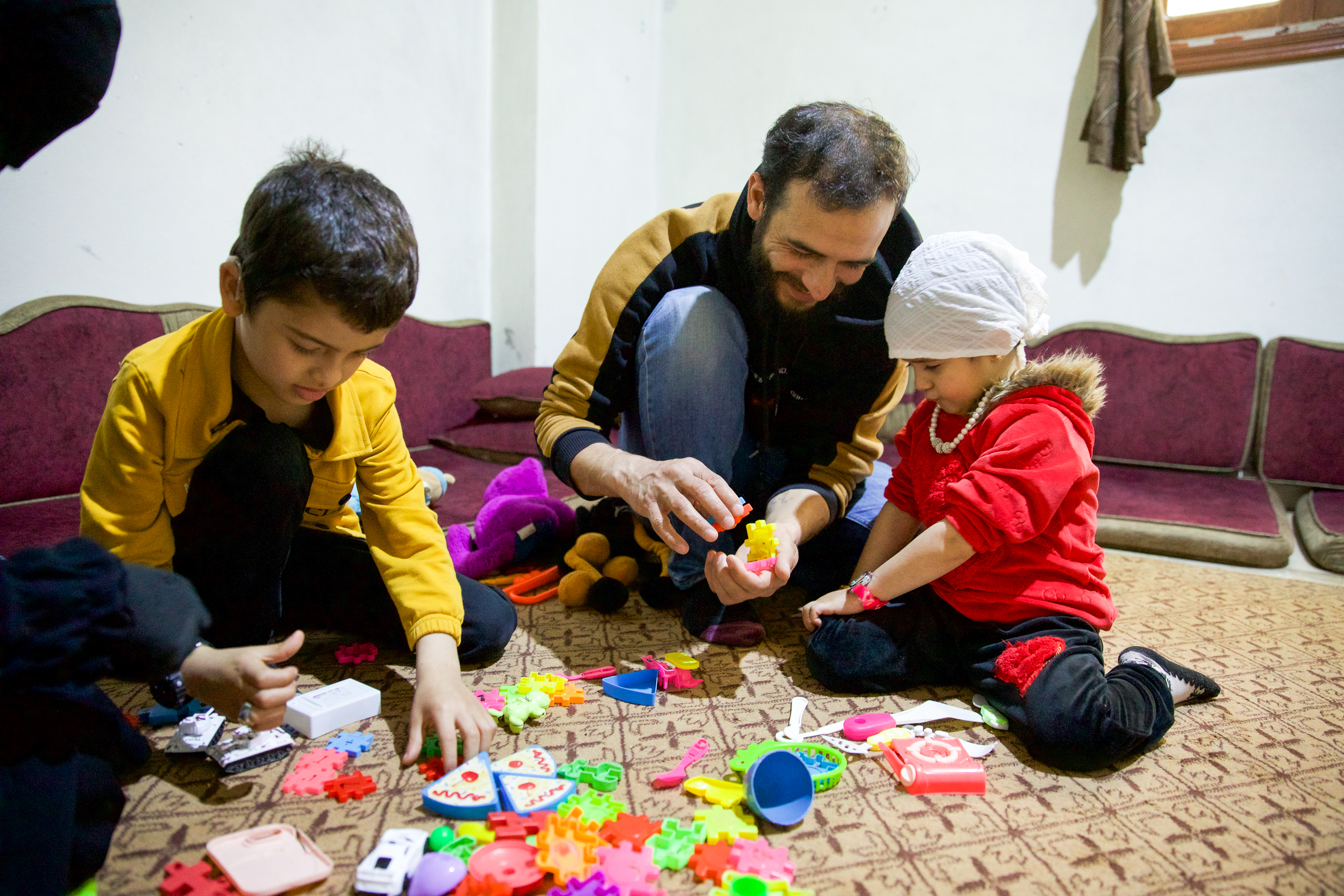 Father plays with his two children