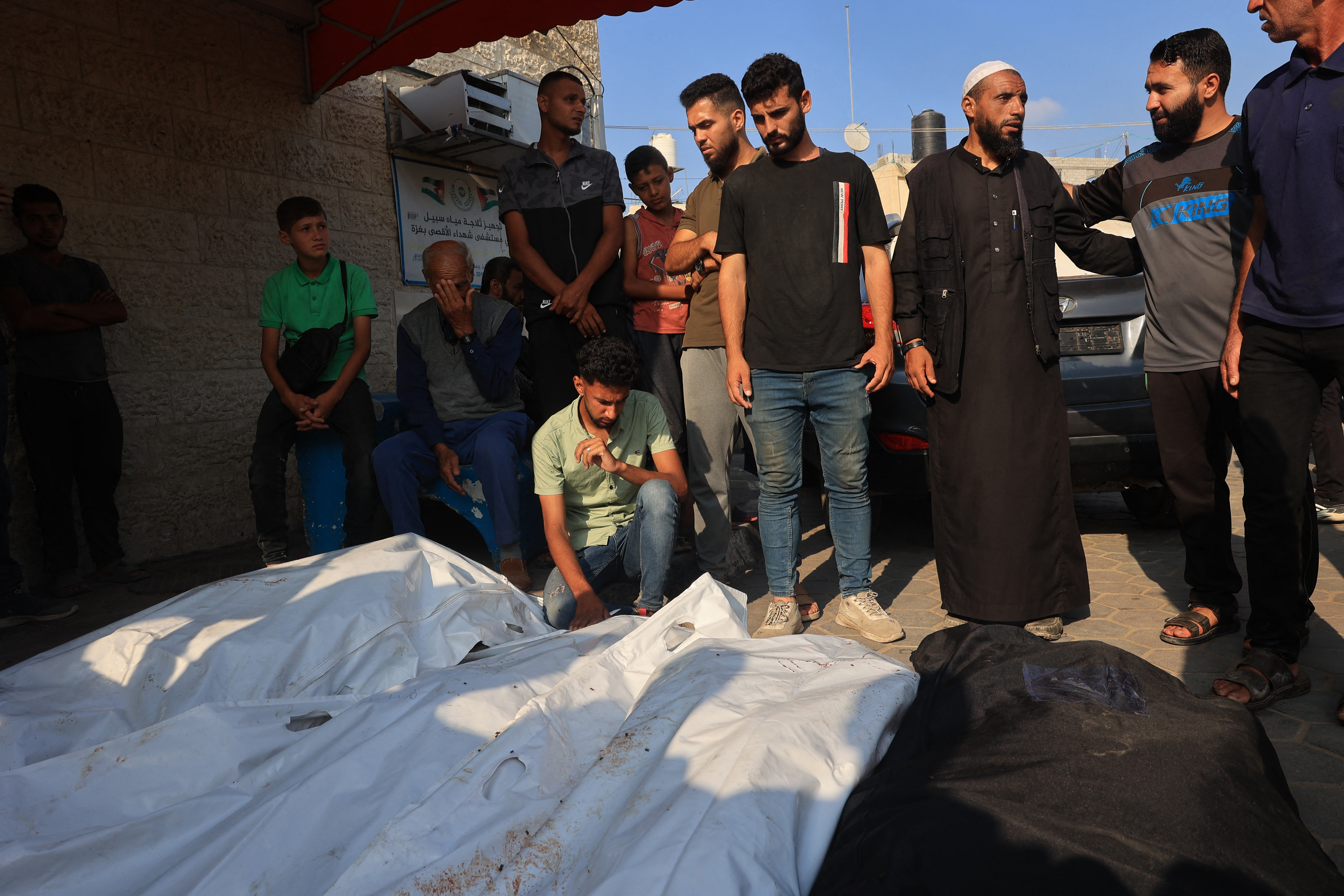 Palestinians surround body bags containing victims of Israeli bombardment in the yard of the al-Aqsa Martyr's hospital in Deir el-Balah in the central Gaza Strip on July 7, 2024. Israel carried out deadly air strikes in the Gaza Strip on July 7 as the war between Israel and the Hamas movement entered its 10th month, with fighting raging across the Palestinian territory and fresh diplomatic efforts underway to halt the violence. (Photo by Eyad BABA / AFP)