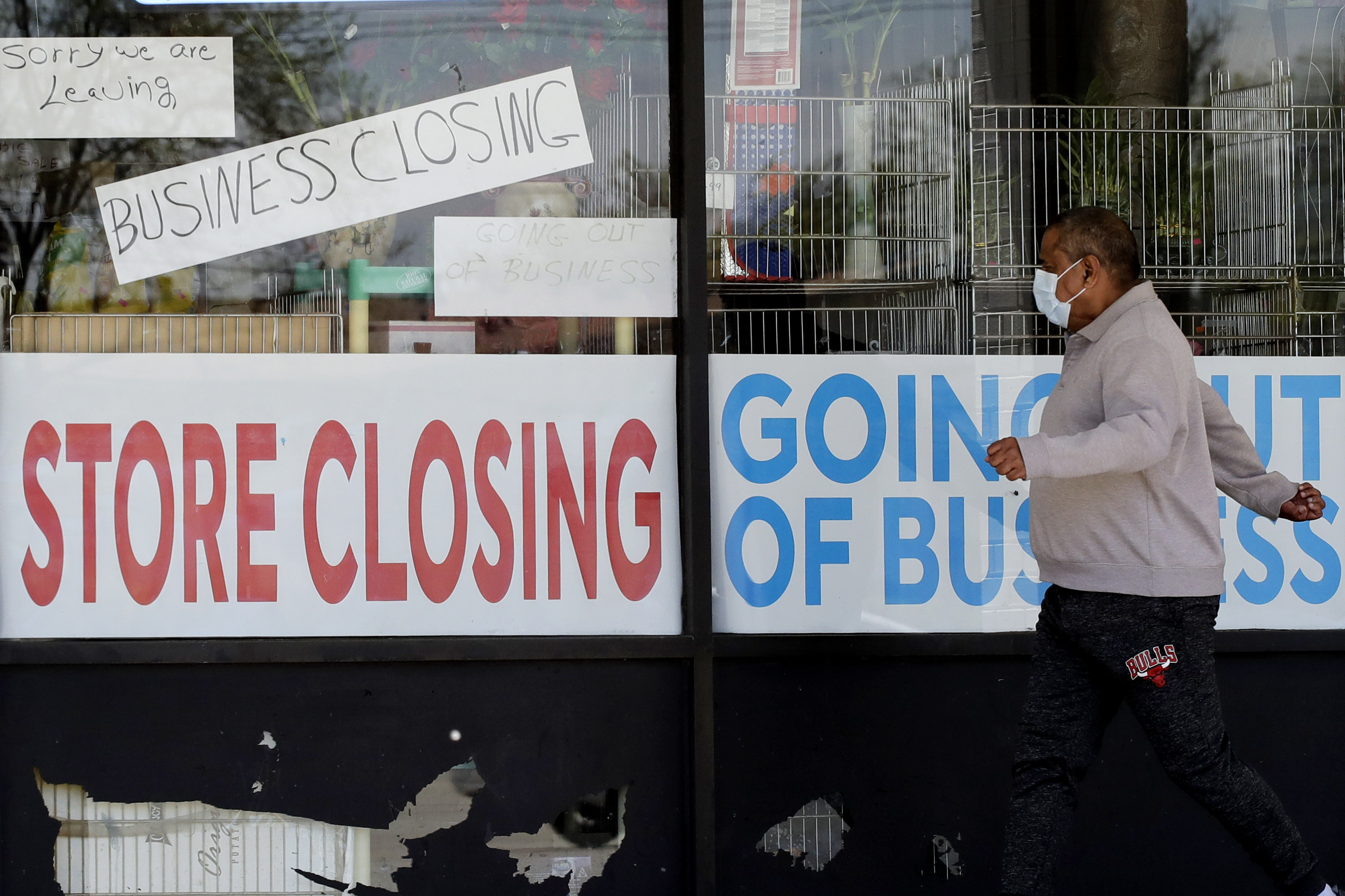 A man looks at signs of a closed store due to COVID-19 in Niles