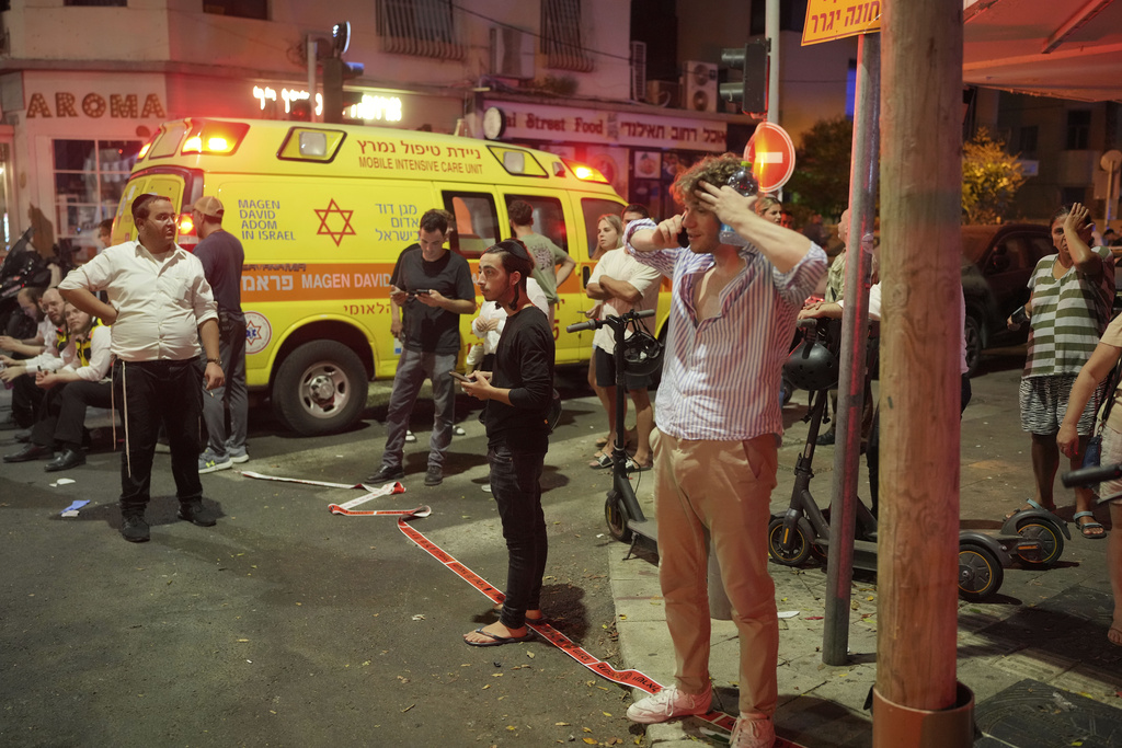 People gather at the scene of an deadly explosion in Tel Aviv, Israel, early Friday, July 19, 2024. (AP Photo/Erik Marmor)