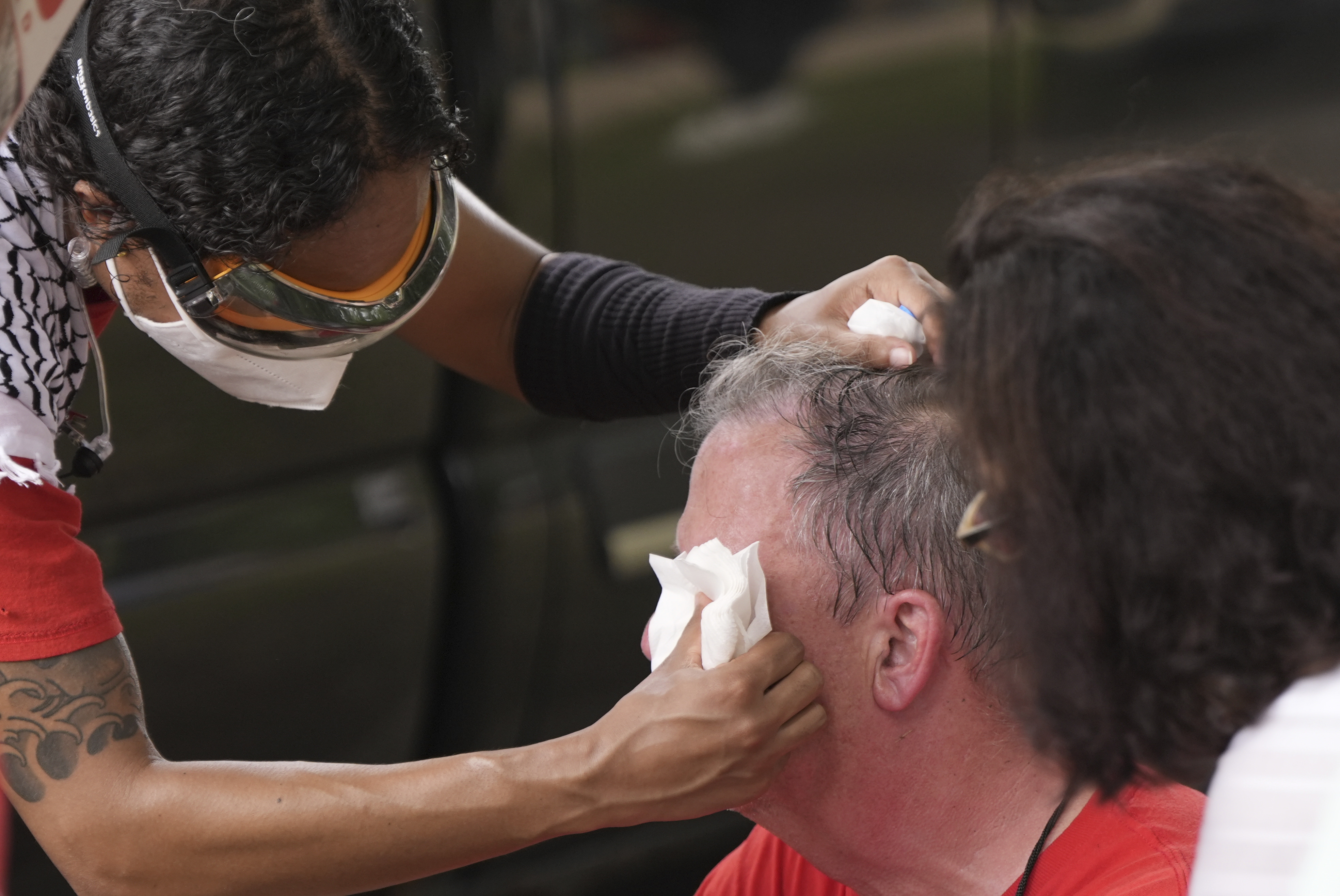 Protester gets his eyes tended to after pepper spray.