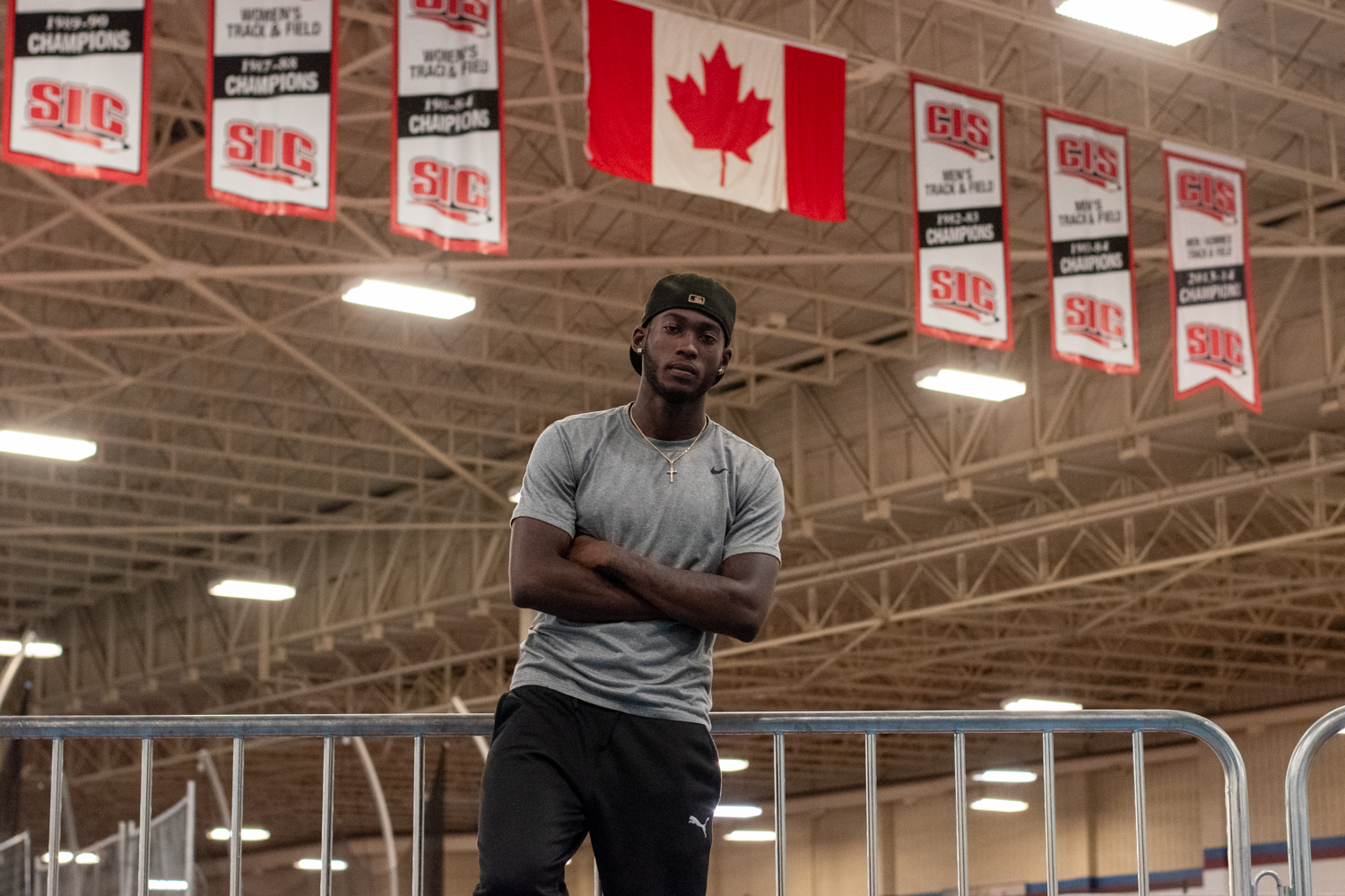 Tamarri Lindo poses under the Canadian flag in an indoor sports arena.