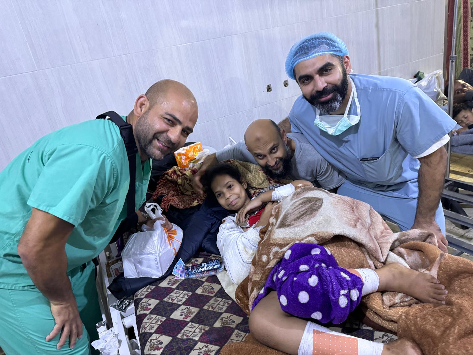 Omar Sabha, a colleague and Jawad Khan pose for a photo around one of their young patients.