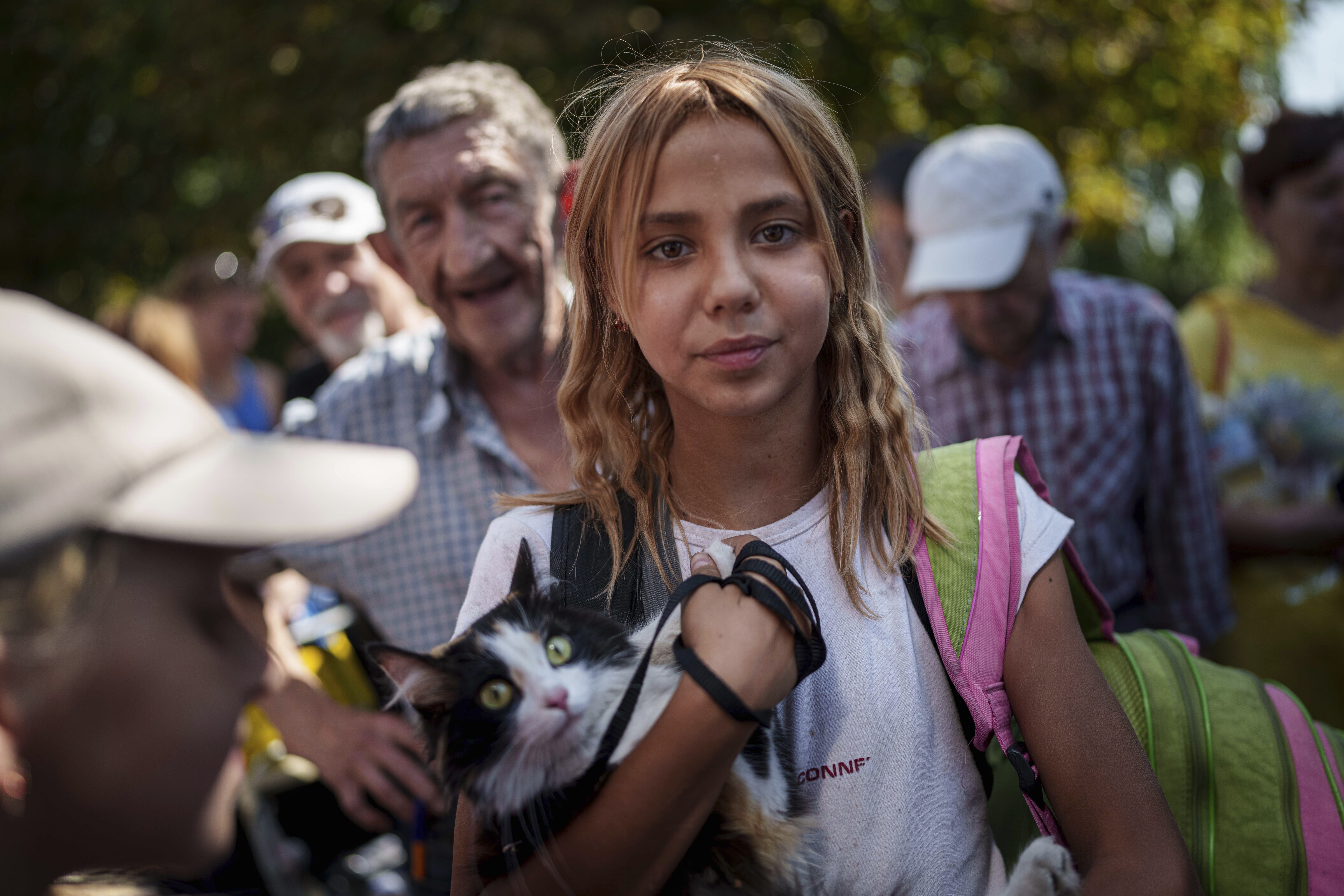 A young woman stays in line for evacuation train in Pokrovsk, Donetsk region, Ukraine, Monday, August 19, 2024. Due to the advance of Russian troops, the war affects more and more new settlements to the west of the Donetsk region. Intensive shelling forced people to leave homes. (AP Photo/Evgeniy Maloletka)
