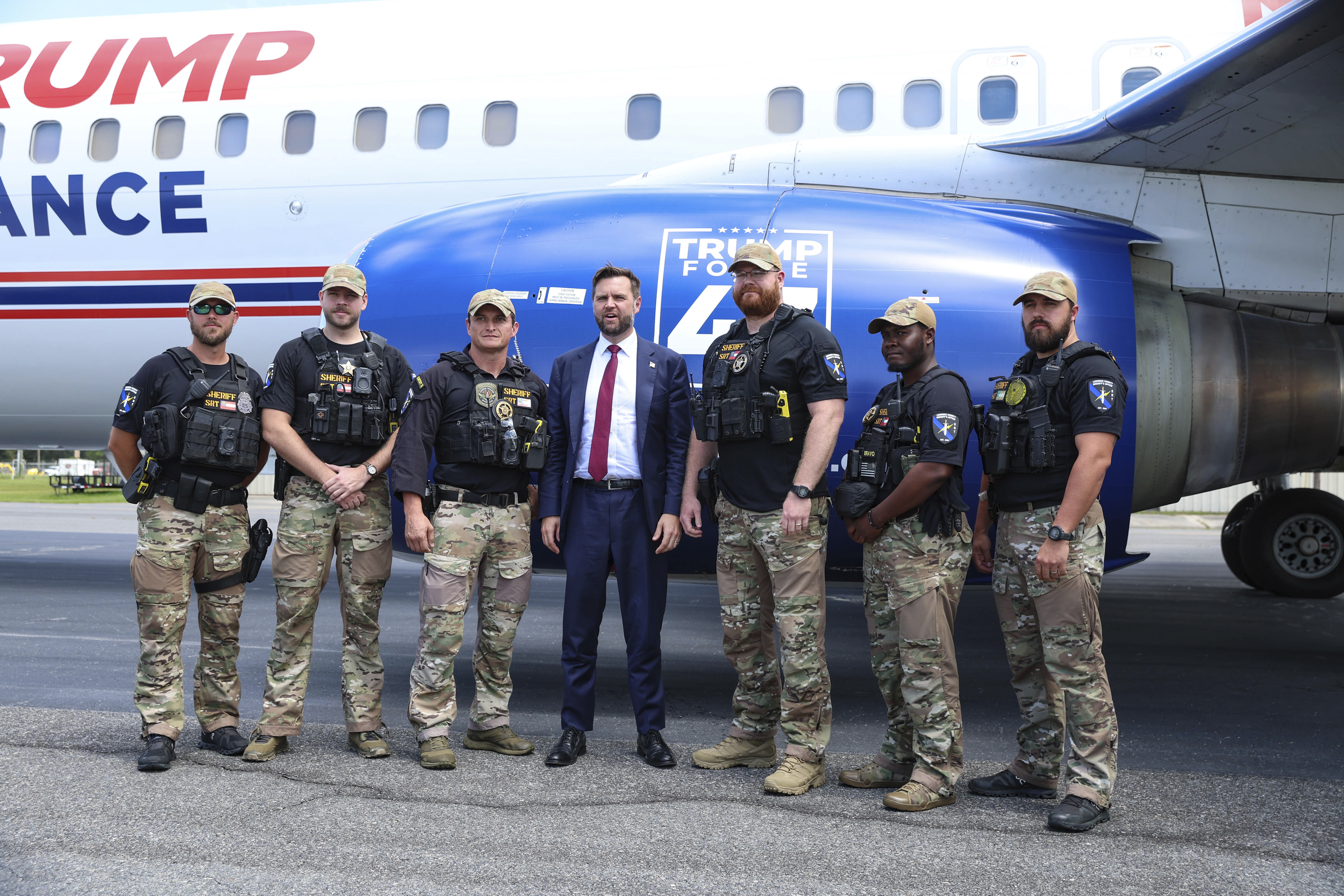 JD Vance poses in front of a Trump campaign plane with members of Lowndes County sheriff's office.